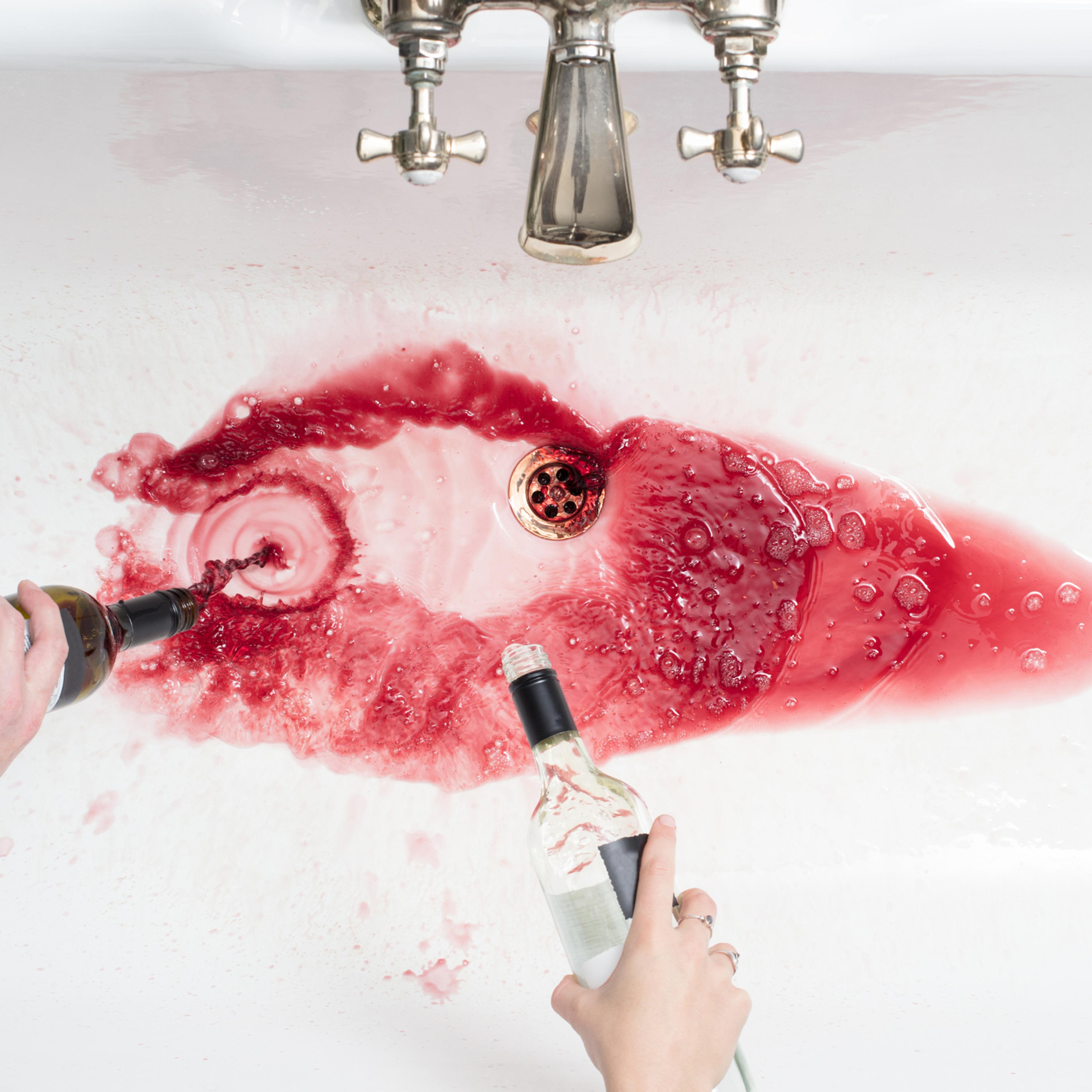 Pouring away wine in an act of giving up alcohol