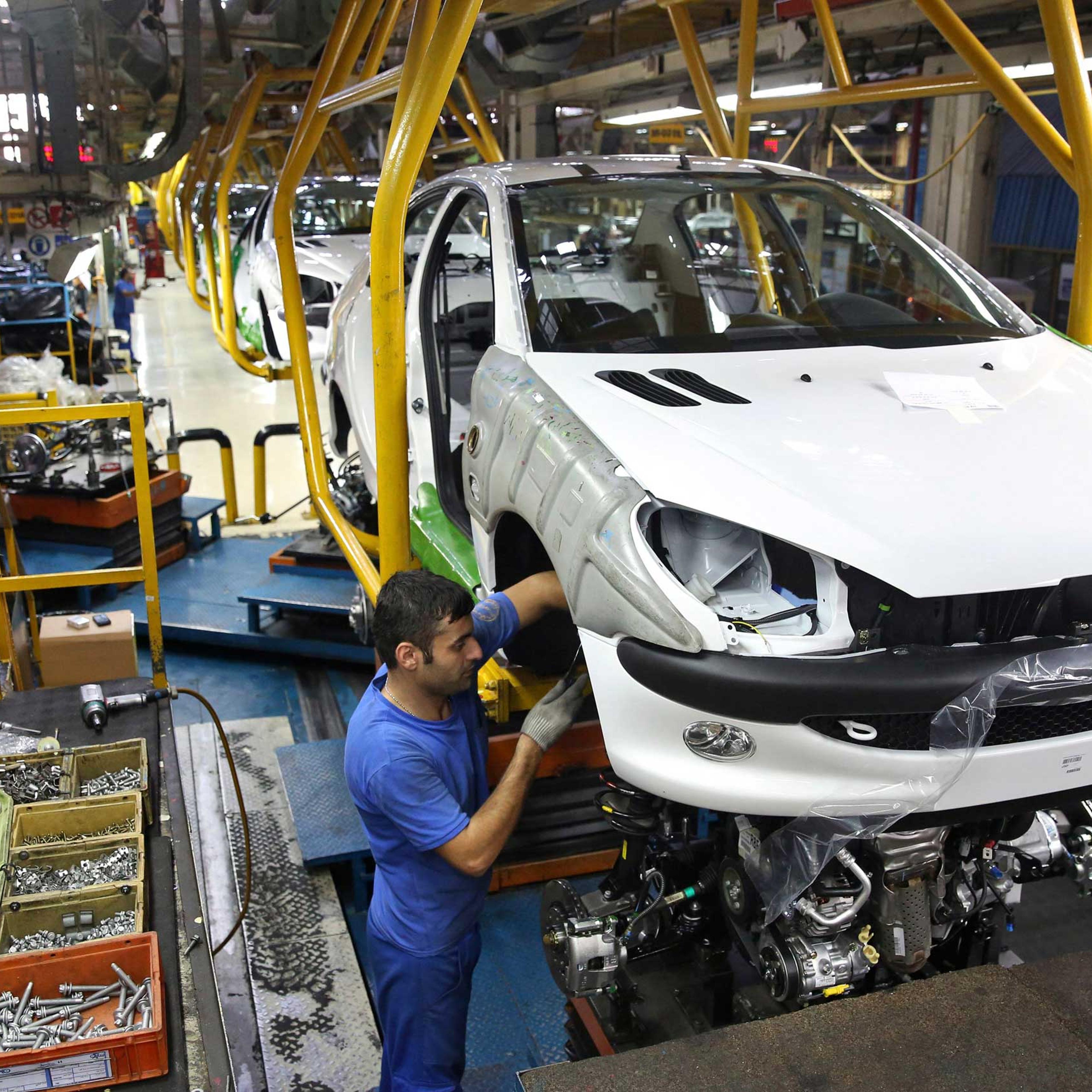 An Iranian worker assembles a Peugeot 206 at the state-run Iran-Khodro automobile manufacturing plant near Tehran, Iran, Oct. 11, 2014.