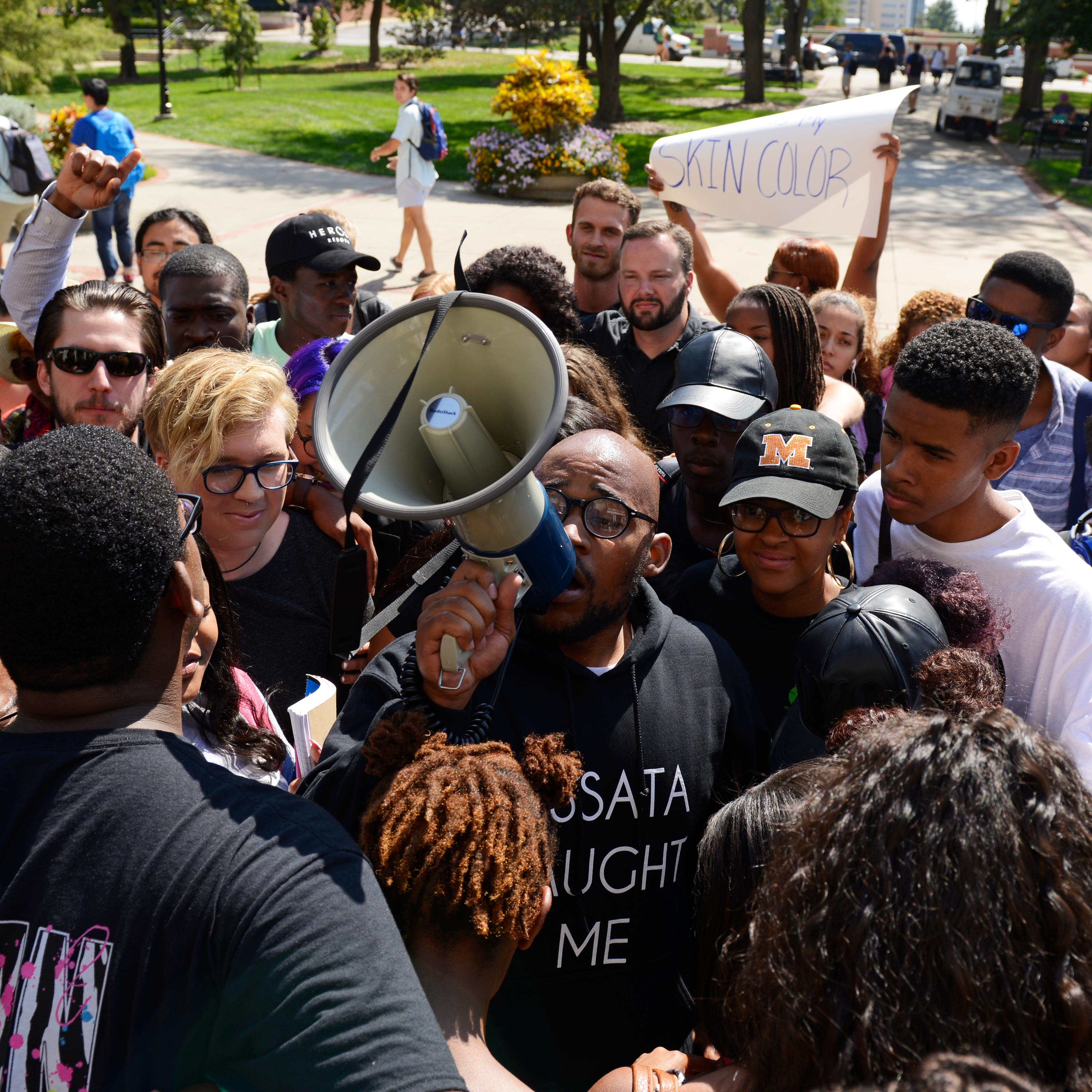 Students gather around graduate student Jonathan Butler for a group hug after marching into Jesse Hall on the University of Missouri campus in Columbia, Mo. on Sept. 24, 2015.