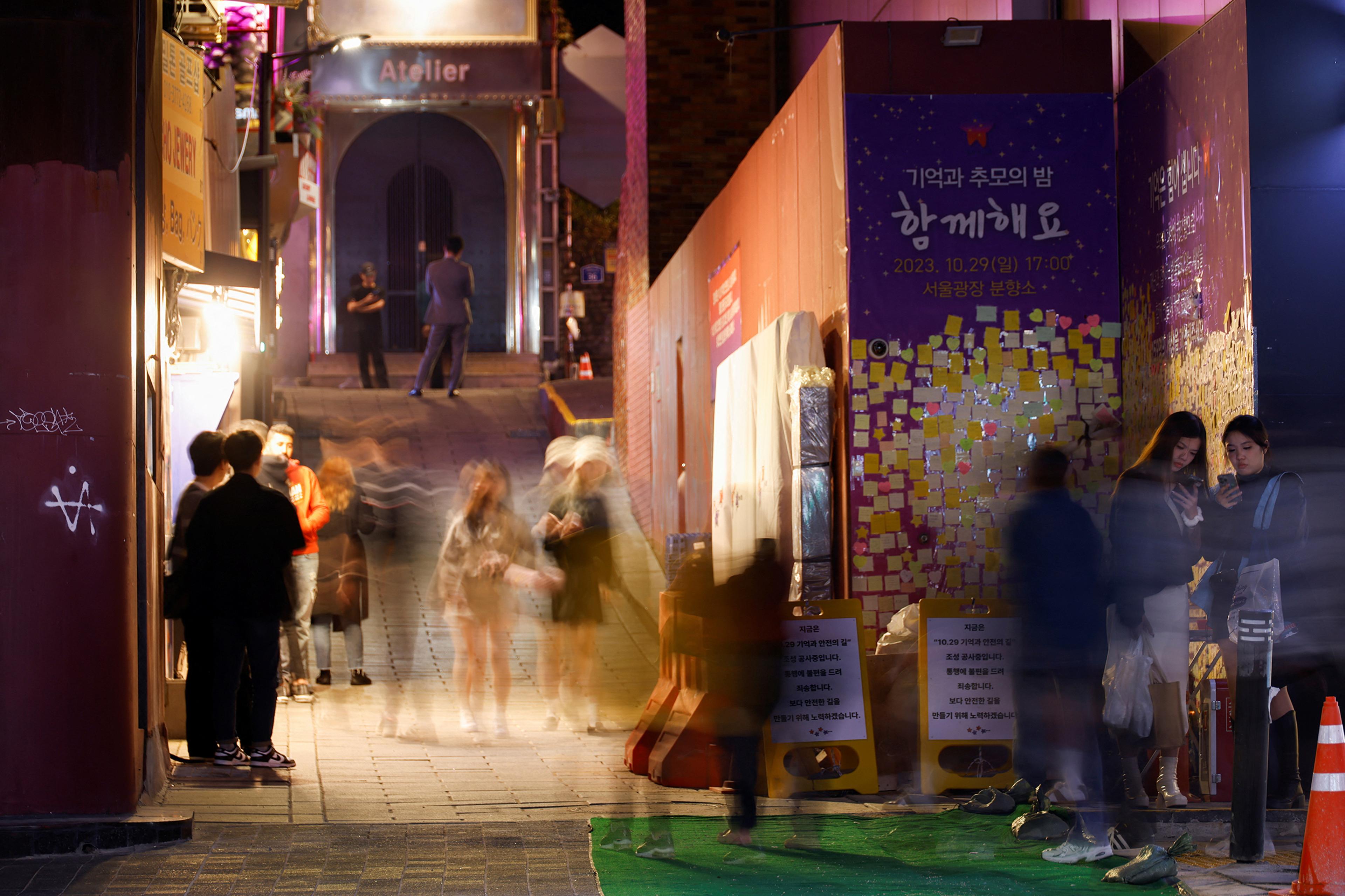 People walk through an alley in Itaewon where the Halloween crowd crush occurred last year, in Seoul, South Korea, on Oct. 23.