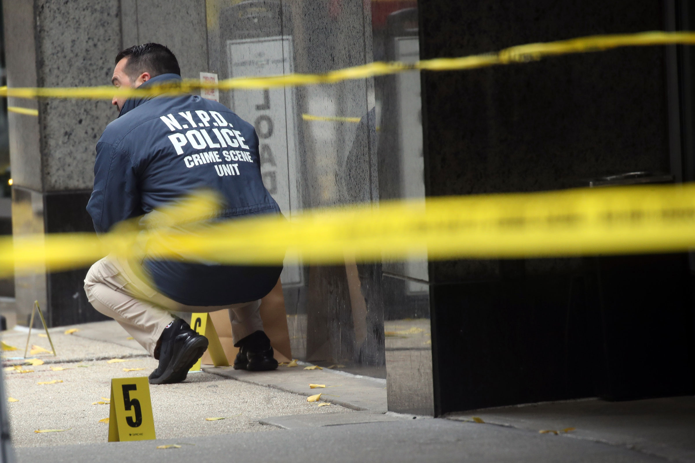 Police place bullet casing markers outside of a Hilton Hotel in Midtown Manhattan where United Healthcare CEO Brian Thompson was fatally shot on Dec. 4, 2024.