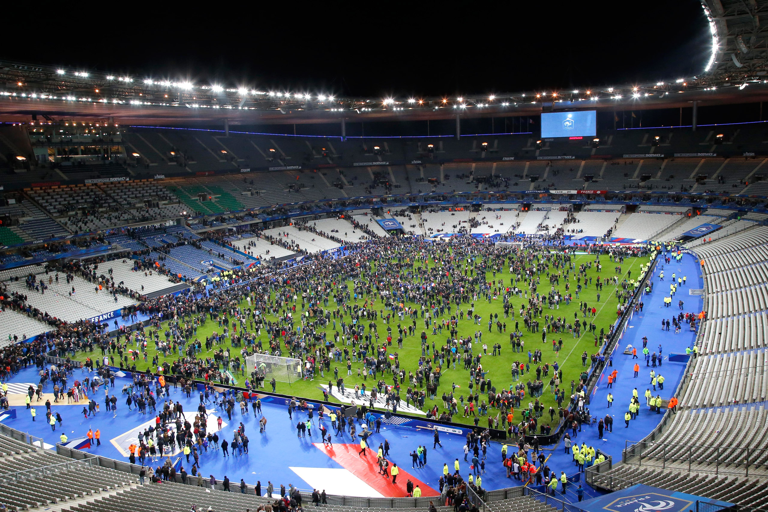 Spectators invade the pitch of the Stade de France stadium after the international friendly soccer France against Germany, Friday, Nov. 13, 2015 in Saint Denis, outside Paris. At least 35 people were killed in shootings and explosions around Paris, many 