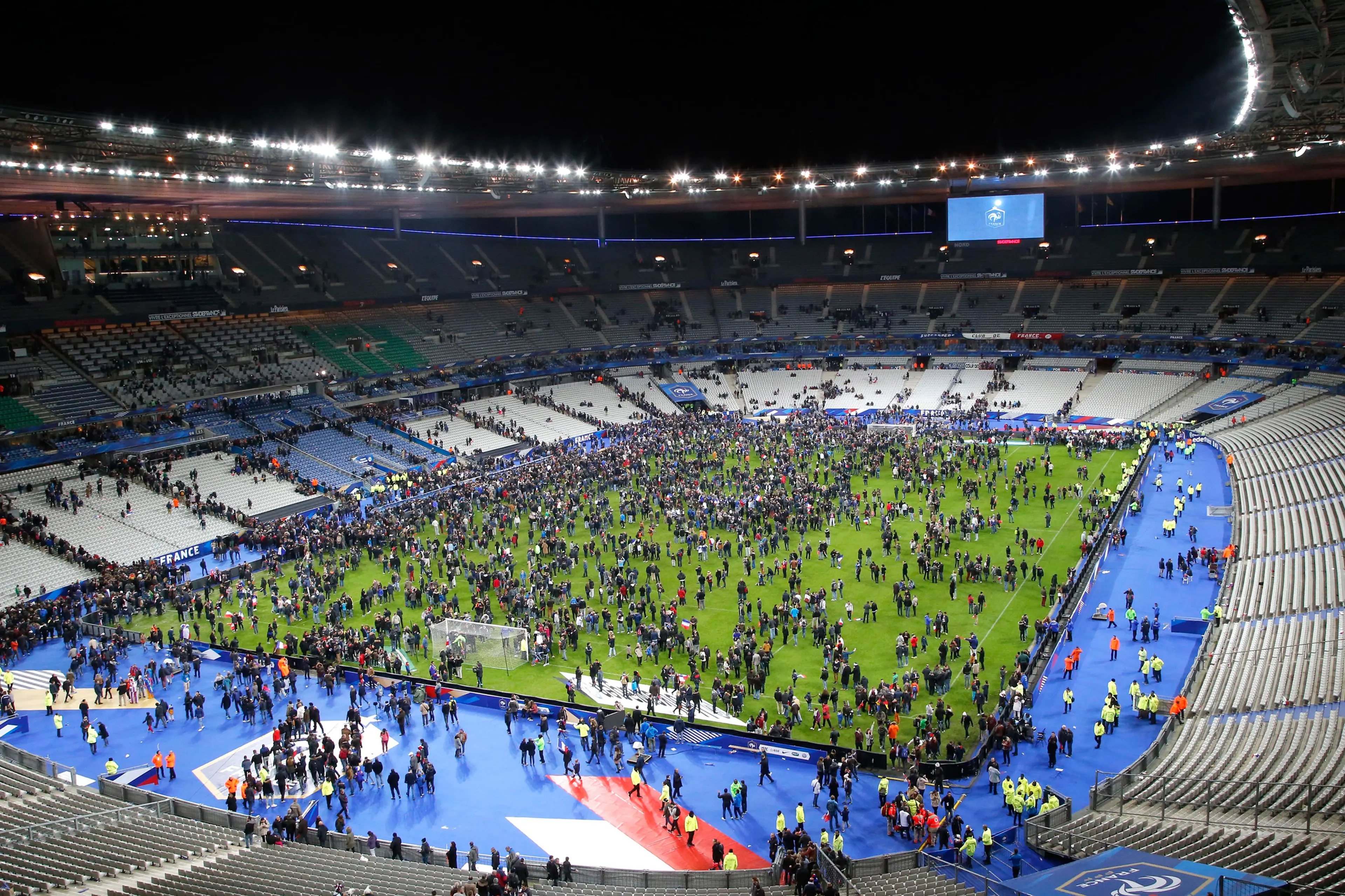 Spectators invade the pitch of the Stade de France stadium after the international friendly soccer France against Germany, Friday, Nov. 13, 2015 in Saint Denis, outside Paris. At least 35 people were killed in shootings and explosions around Paris, many