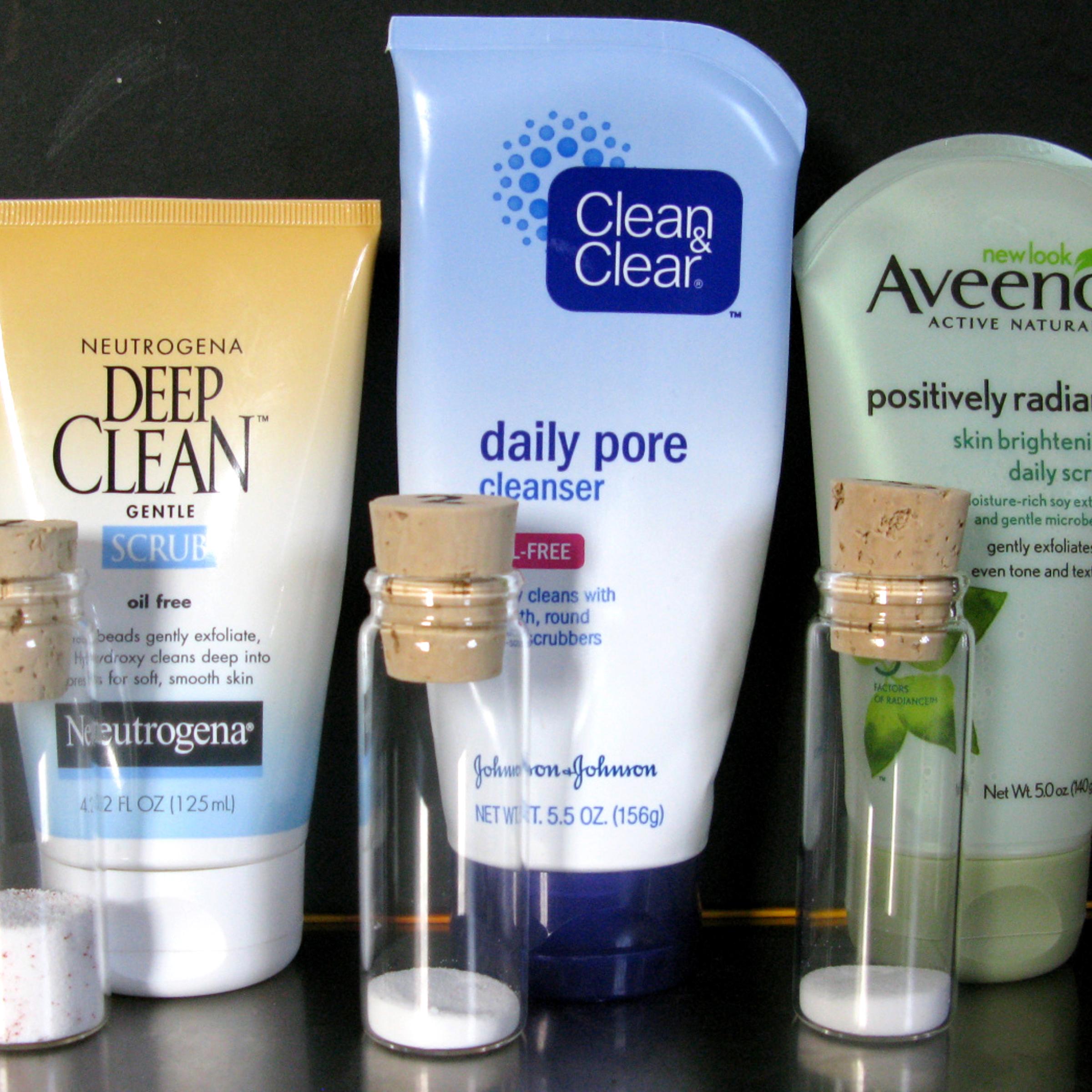Vials of microbeads alongside products that use such small, plastic spheres.