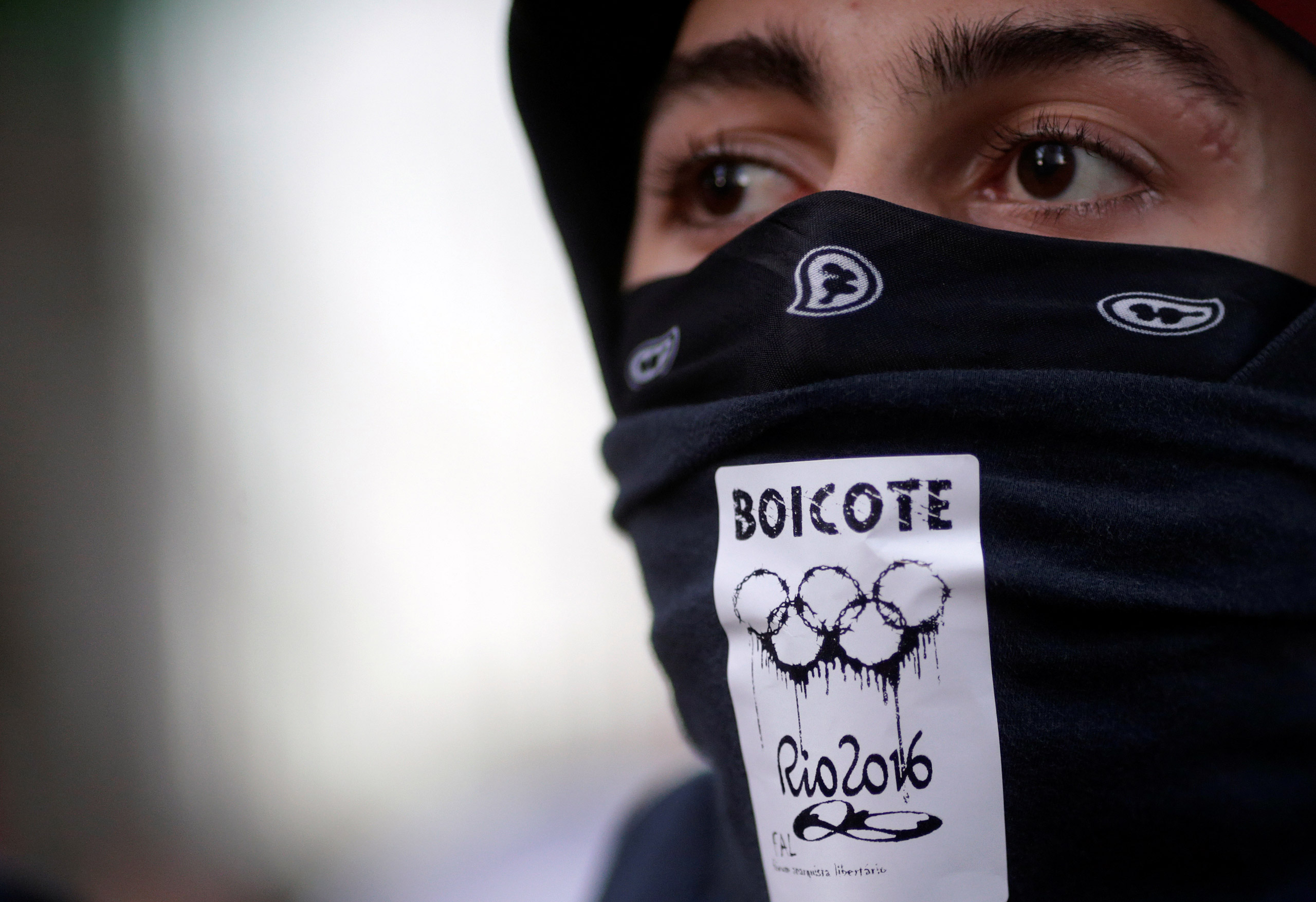 An anti-government demonstrator, with a sticker which reads "boycott" on his mask, attends a protest on the Rio de Janeiro state economic crisis and against 2016 Rio Olympics, in Rio de Janeiro, Brazil, July 6, 2016. REUTERS/Ricardo Moraes - RTX2K27V