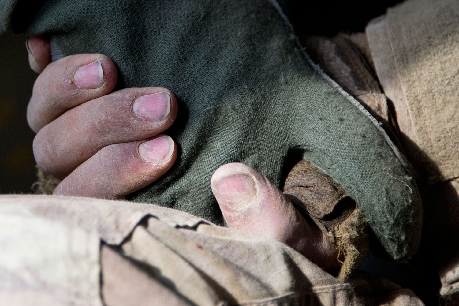 A wounded U.S. soldier holds the hand of a flight-medic as he is airlifted by a medevac (medical evacuation) helicopter from the 159th Brigade Task Force Thunder to Kandahar Hospital Role 3, on August 23, 2011. Three soldiers were wounded while their vehicle was destroyed up by an Improvised Explosive Devise (IED).