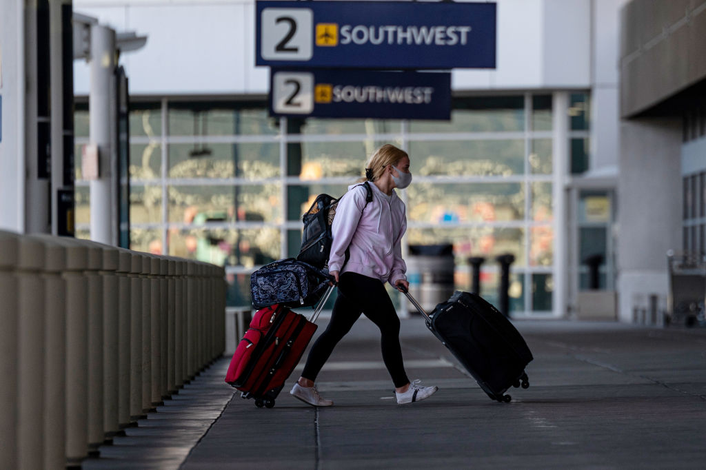 A traveler wearing a protective mask walks to the Southwest Airlines check-in area at Oakland International Airport in Oakland, California, U.S., on Tuesday, Jan. 19, 2021.