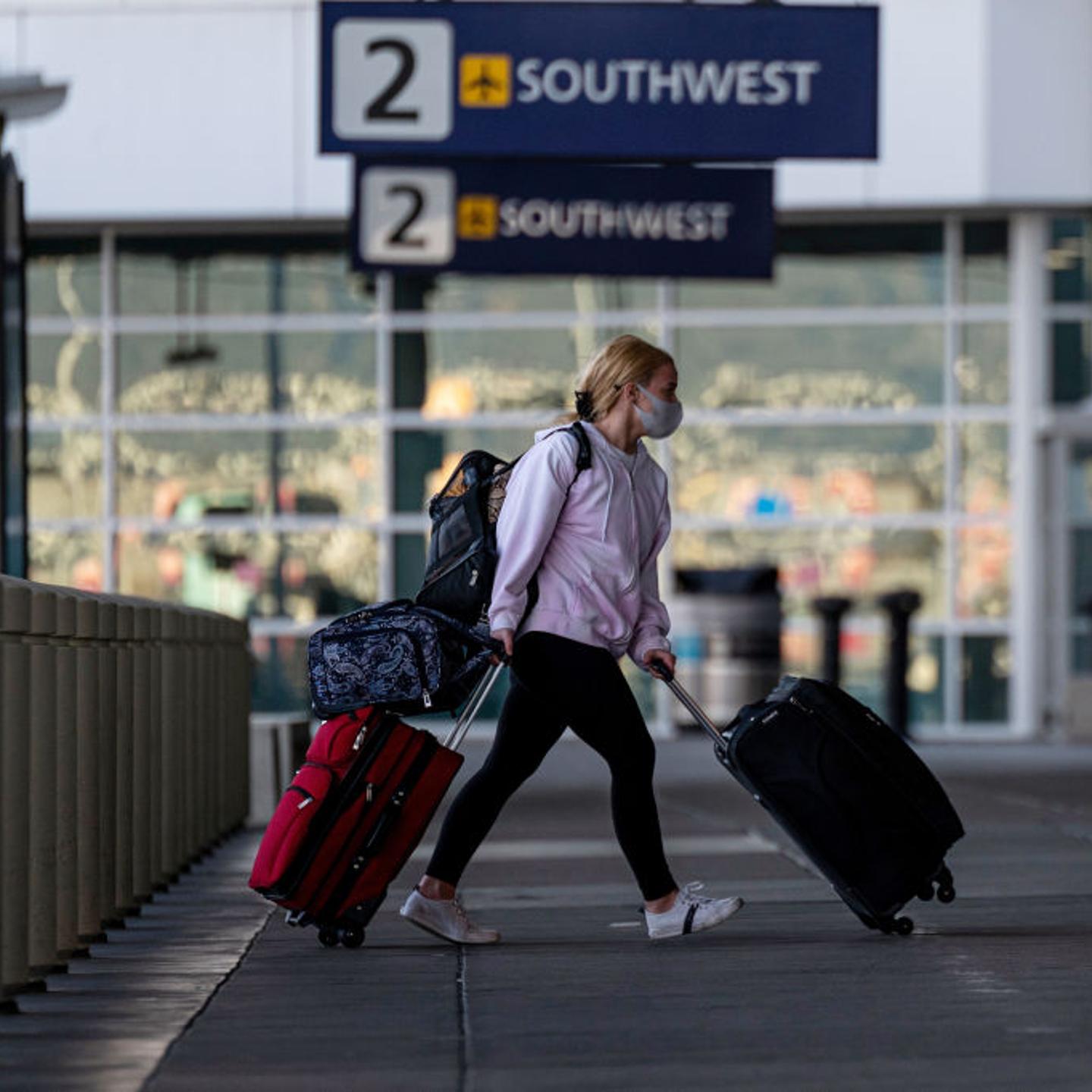 A traveler wearing a protective mask walks to the Southwest Airlines check-in area at Oakland International Airport in Oakland, California, U.S., on Tuesday, Jan. 19, 2021.