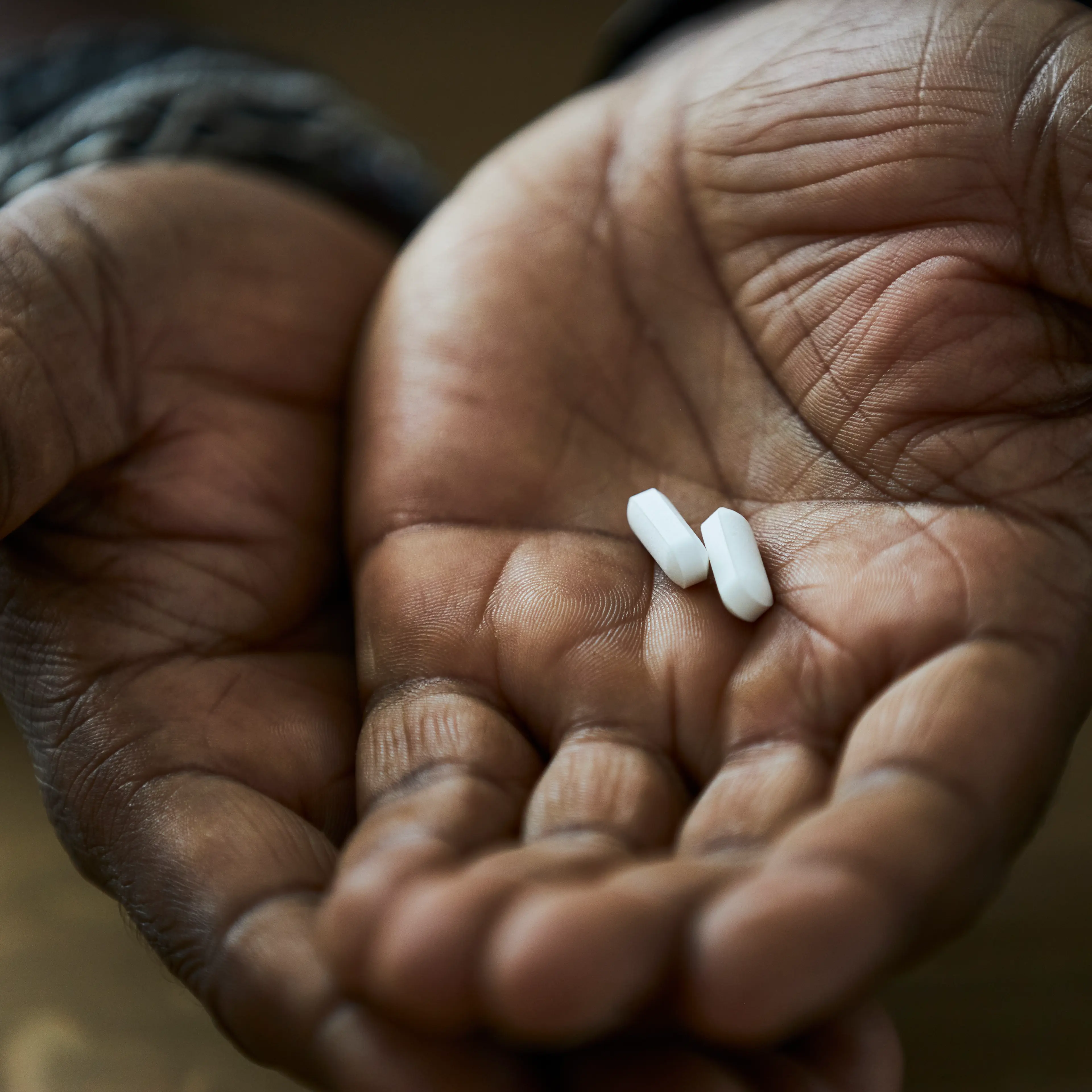 Two hands hold pills