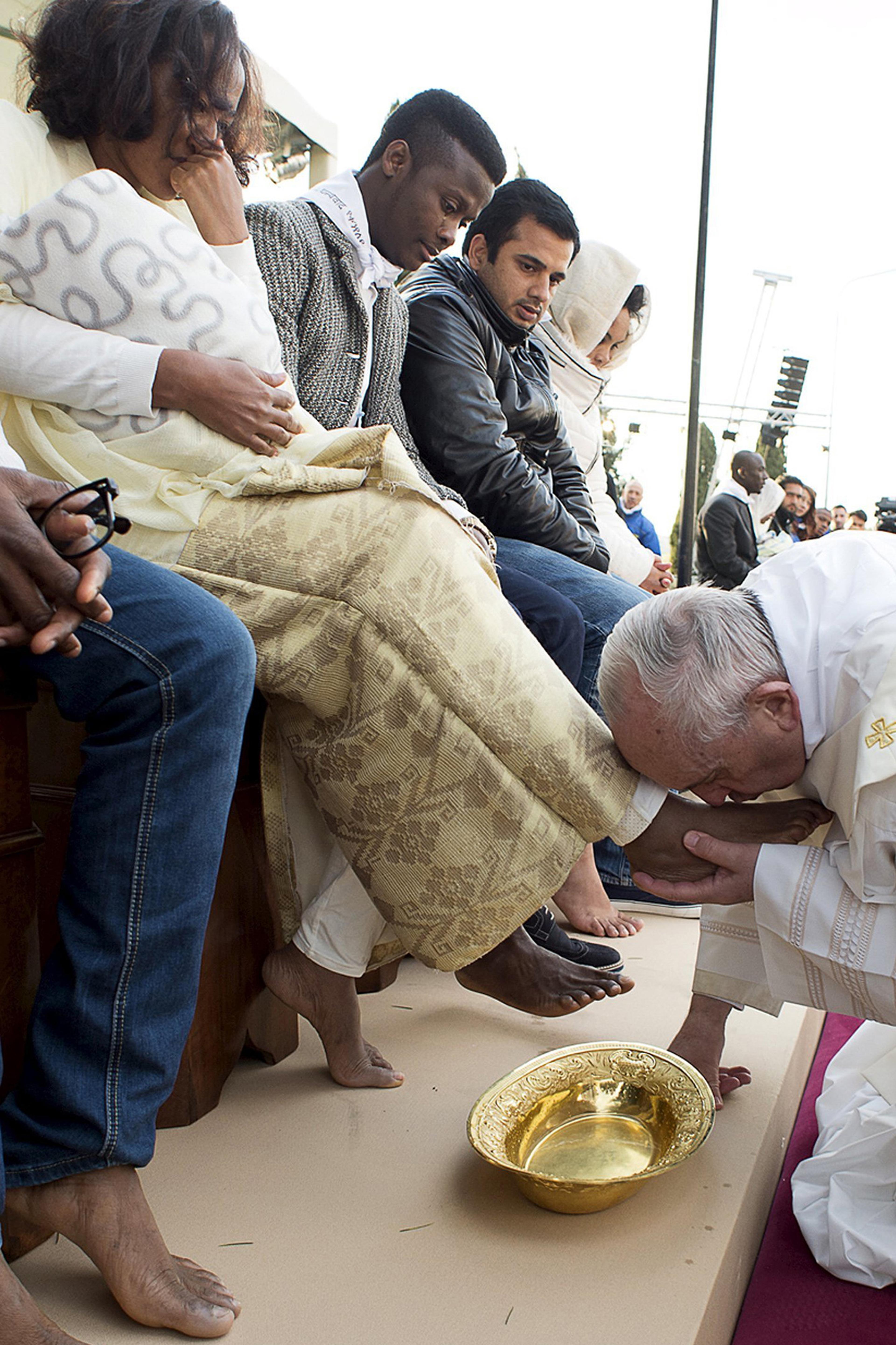 Pope Francis kisses the foot of a refugee during the foot-washing ritual at the Castelnuovo di Porto refugees center near Rome, Italy