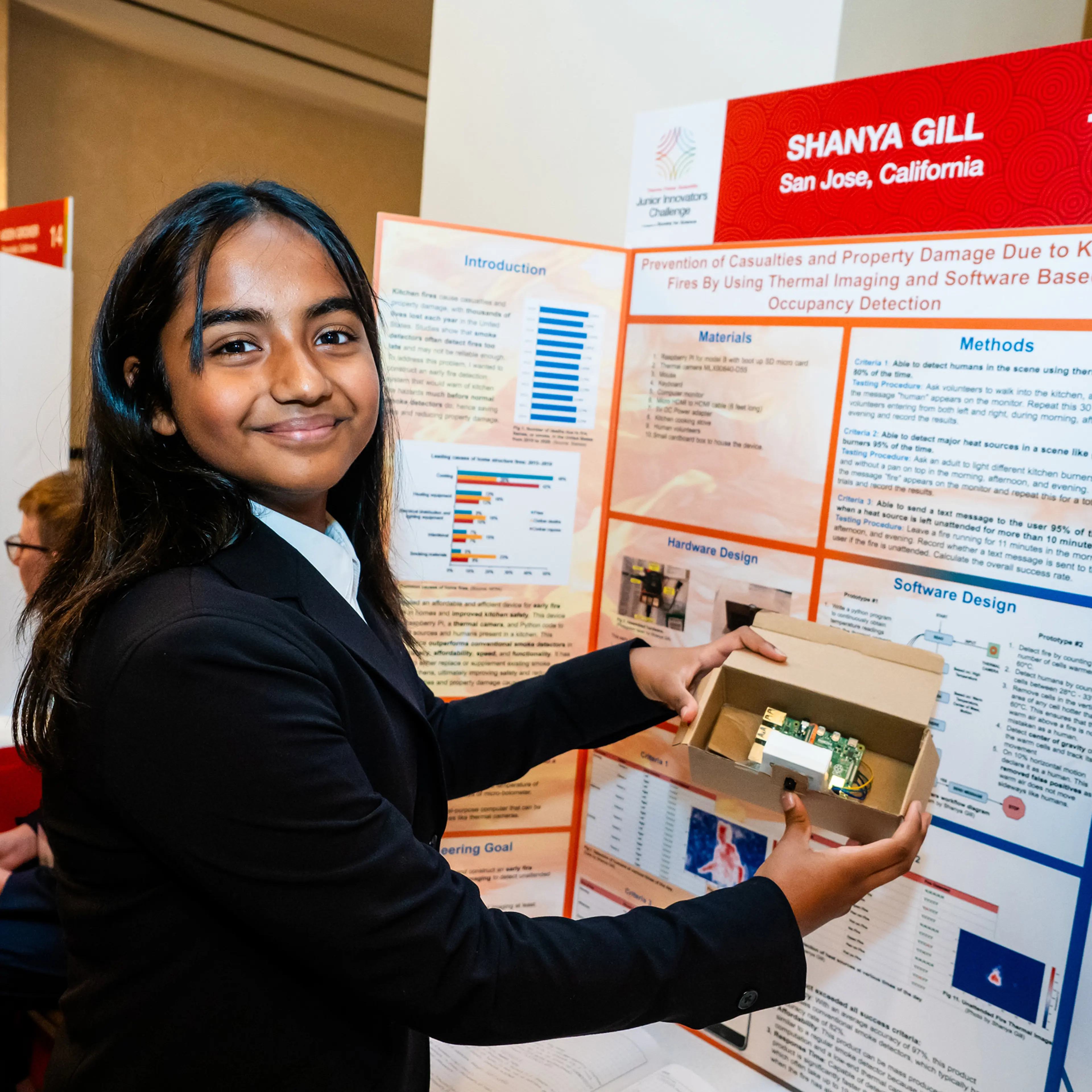 Shanya Gill proudly presents a prototype and plans for her early fire-detection device