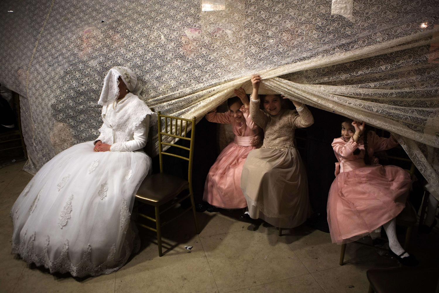 Feb. 18, 2014.
Children peep from behind a curtain next to Jewish ultra-orthodox bride Rivka Hannah (Hofman) during the Mitzvah Tans dance ritual following her wedding in an ultra-orthodox neighborhood of Jerusalem.
