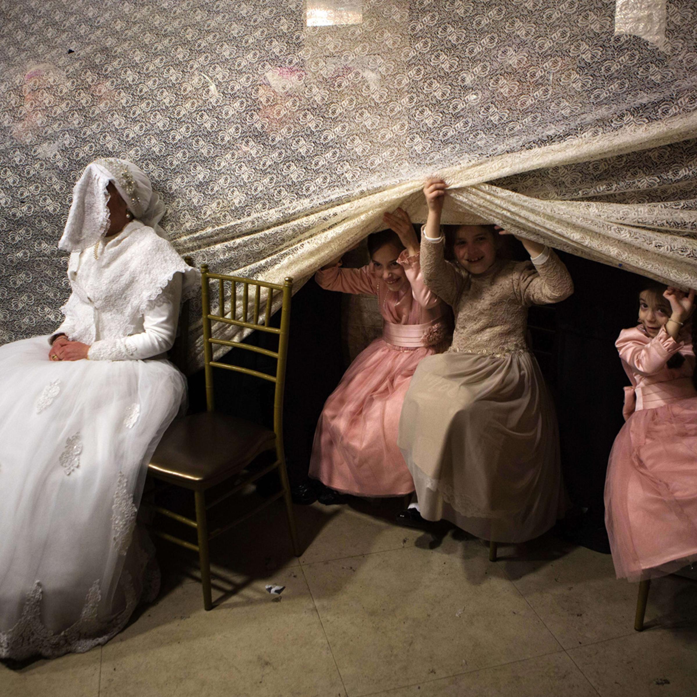 Feb. 18, 2014.
Children peep from behind a curtain next to Jewish ultra-orthodox bride Rivka Hannah (Hofman) during the Mitzvah Tans dance ritual following her wedding in an ultra-orthodox neighborhood of Jerusalem.