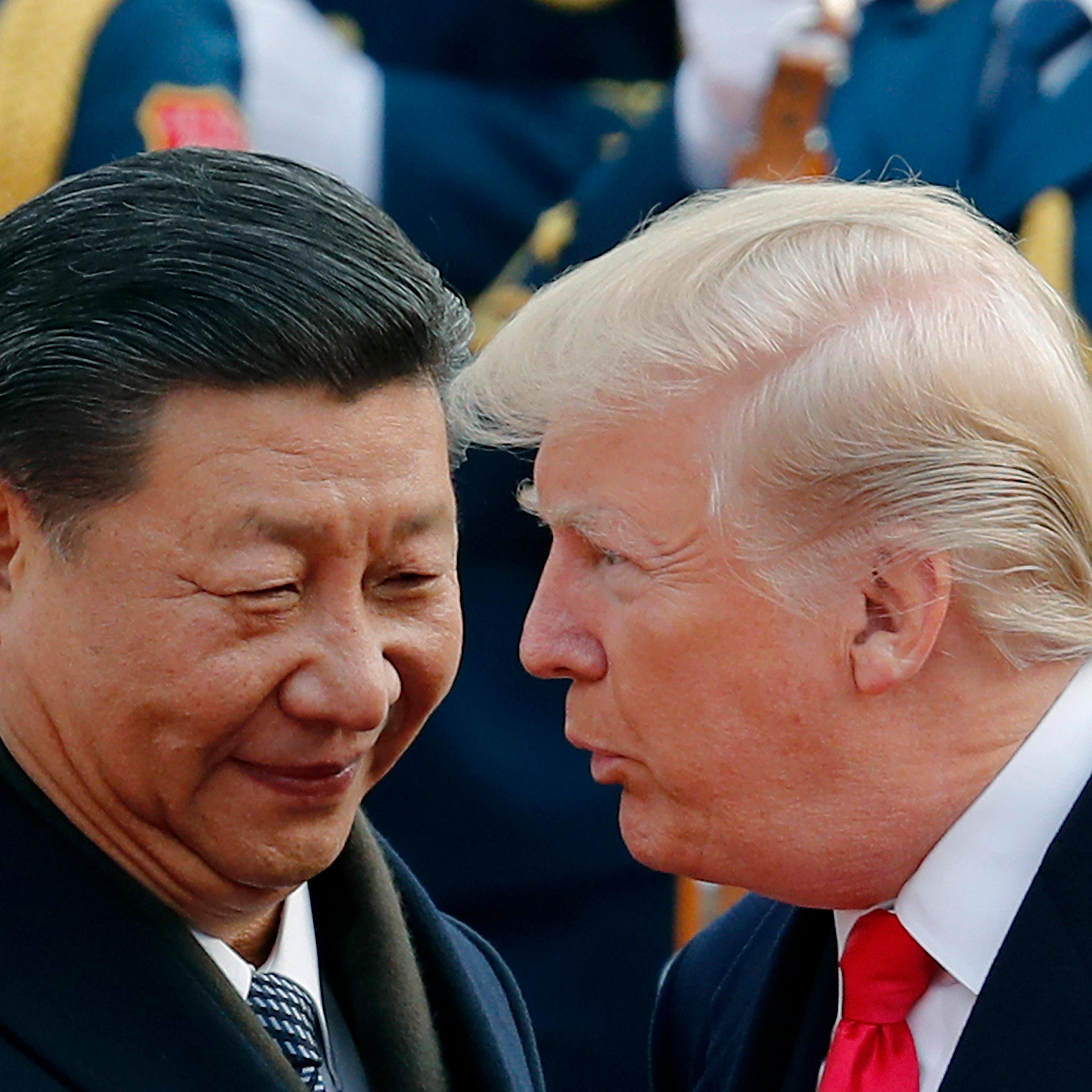 U.S. President Donald Trump chats with Chinese President Xi Jinping during a welcome ceremony at the Great Hall of the People in Beijing on Nov. 9, 2017.