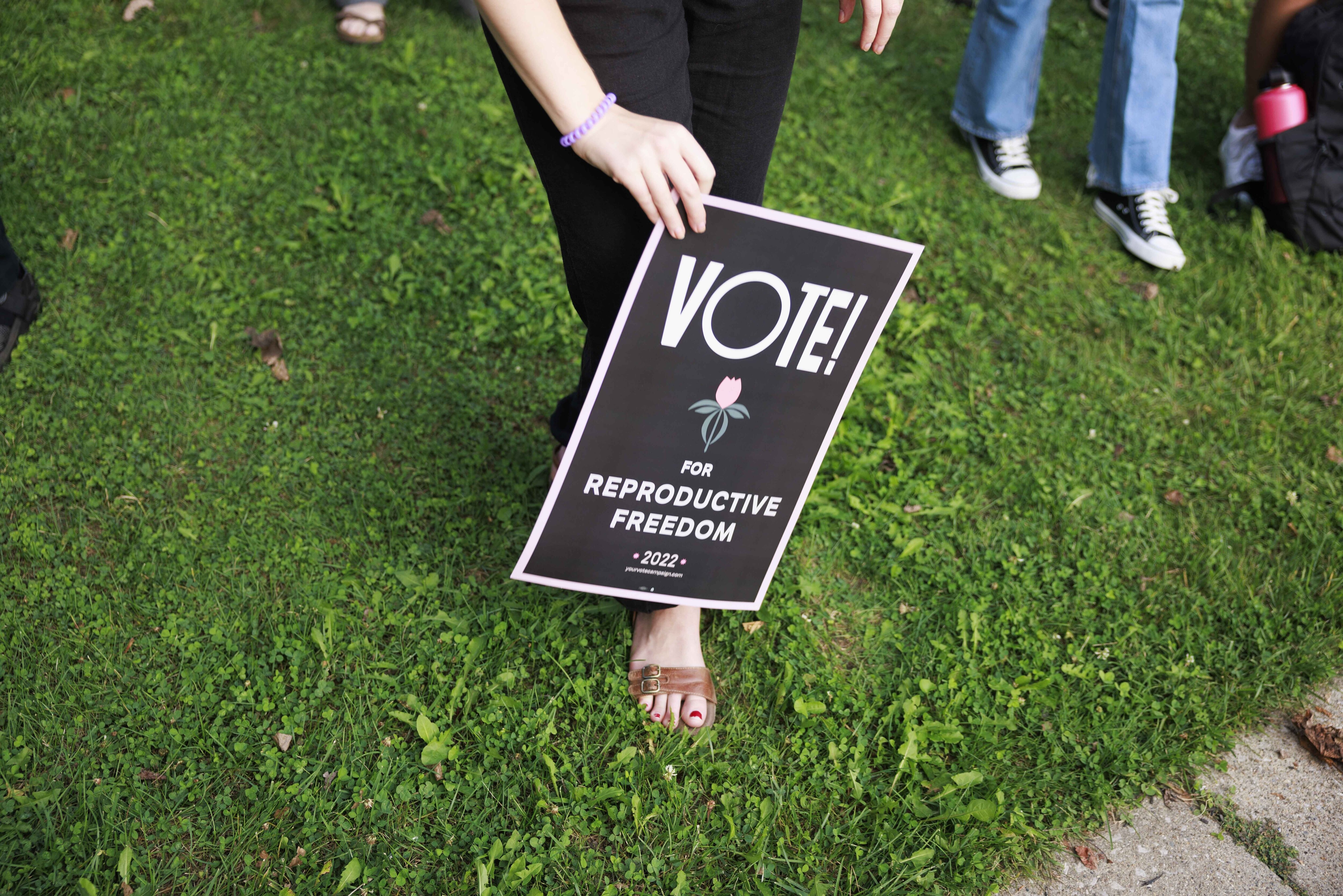 Abortion rights activist holds a placard saying, Vote for