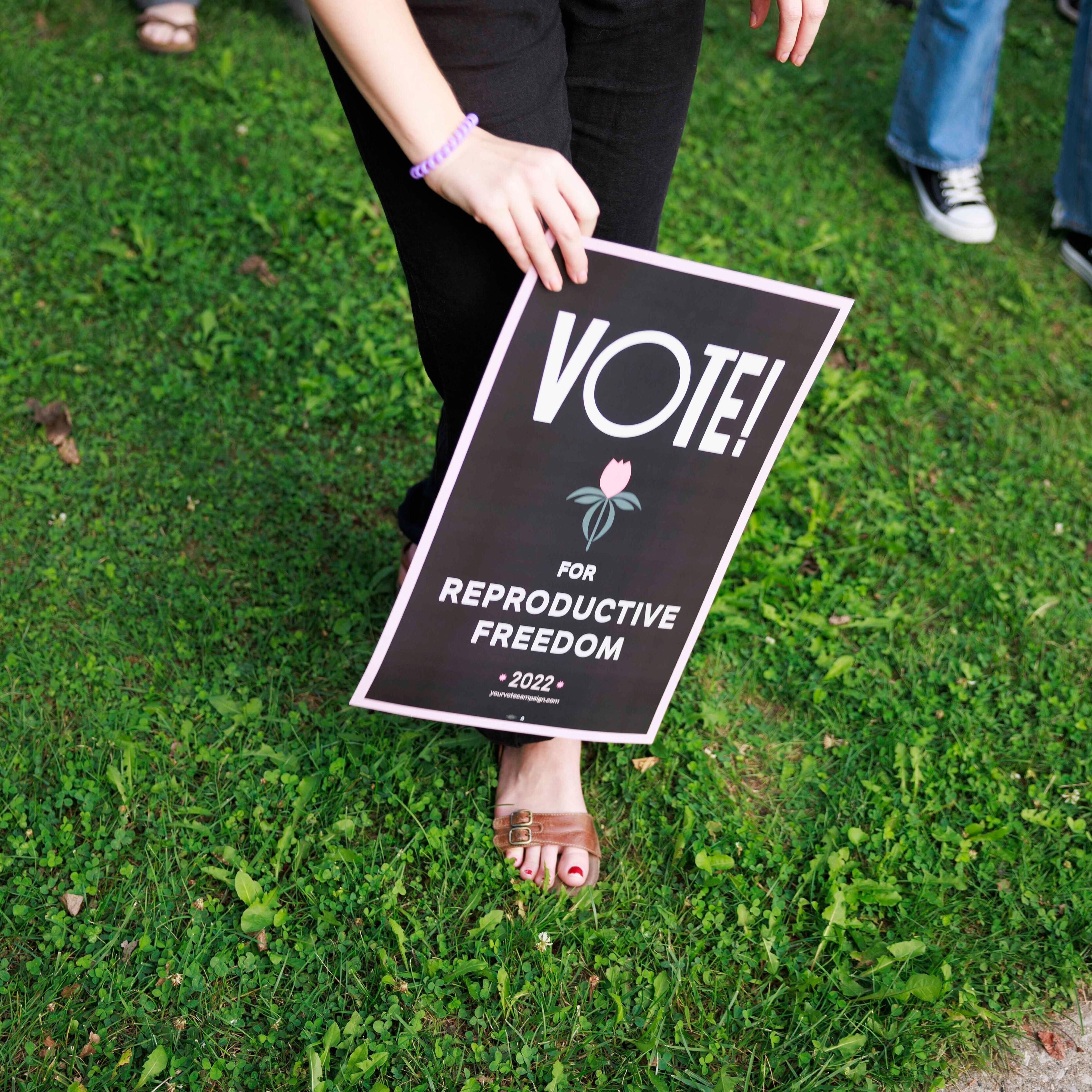 Abortion rights activist holds a placard saying, Vote for