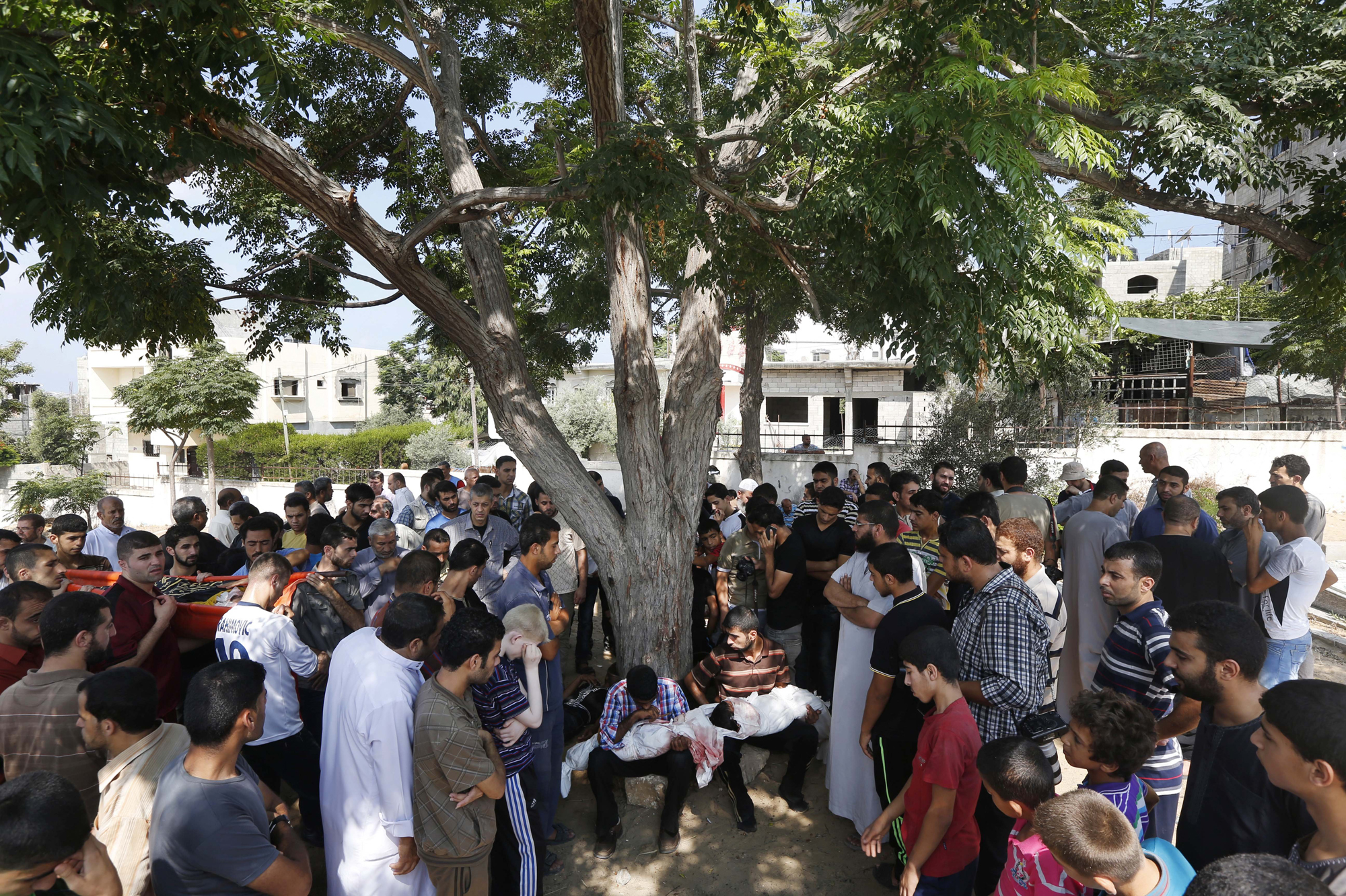 Relatives hold the bodies of Palestinian children Hadi Abdel Nabi, 3, and one and a-half-year-old Abdel Rahman Abdel Nabi, at the cemetery in Jebaliya refugee camp in the northern Gaza Strip, during their funeral, July 24, 2014.