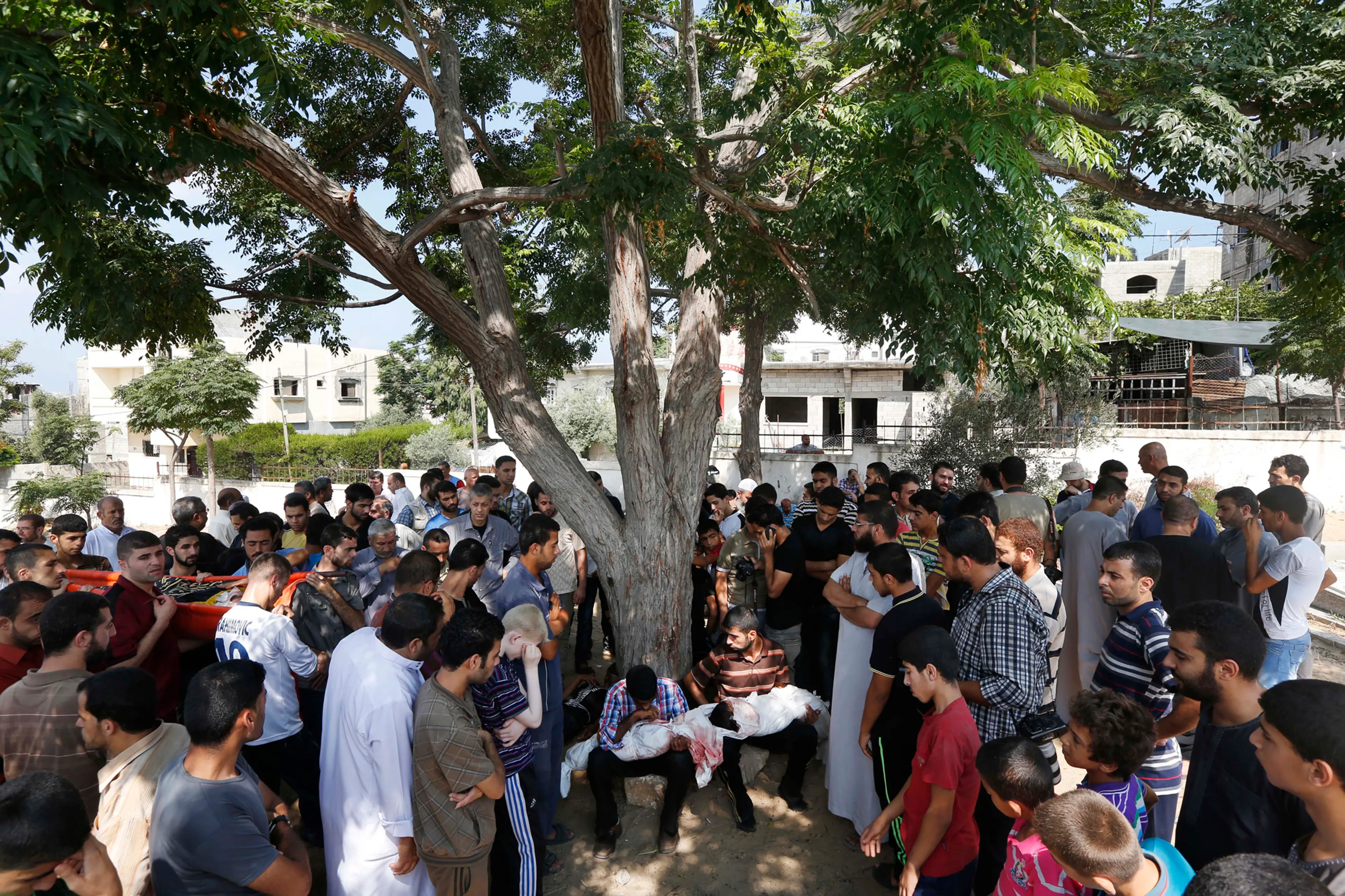 Relatives hold the bodies of Palestinian children Hadi Abdel Nabi, 3, and one and a-half-year-old Abdel Rahman Abdel Nabi, at the cemetery in Jebaliya refugee camp in the northern Gaza Strip, during their funeral, July 24, 2014.