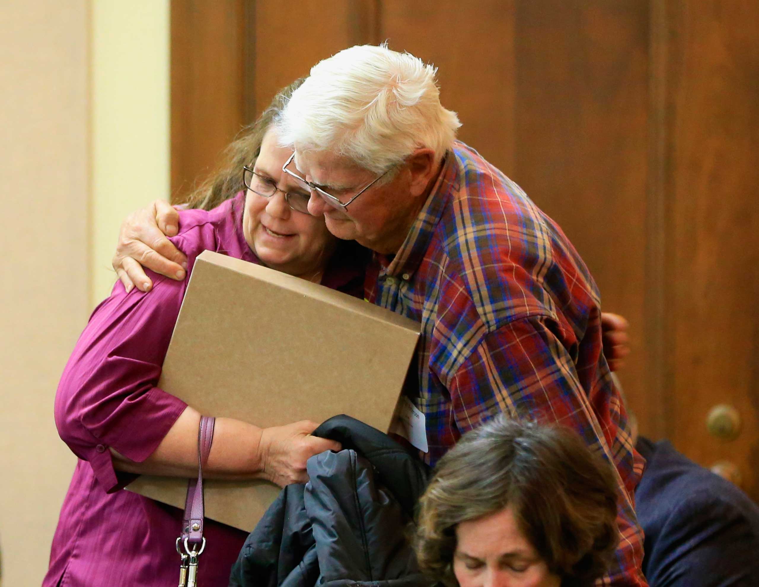 Miriam Thimm Kelle, left, whose brother James Thimm was tortured and killed on a southeast Nebraska farm in 1985, is hugged by Byron Peterson of Scottsbluff, after she testified in favor of a law proposal to change the death penalty to life imprisonment 