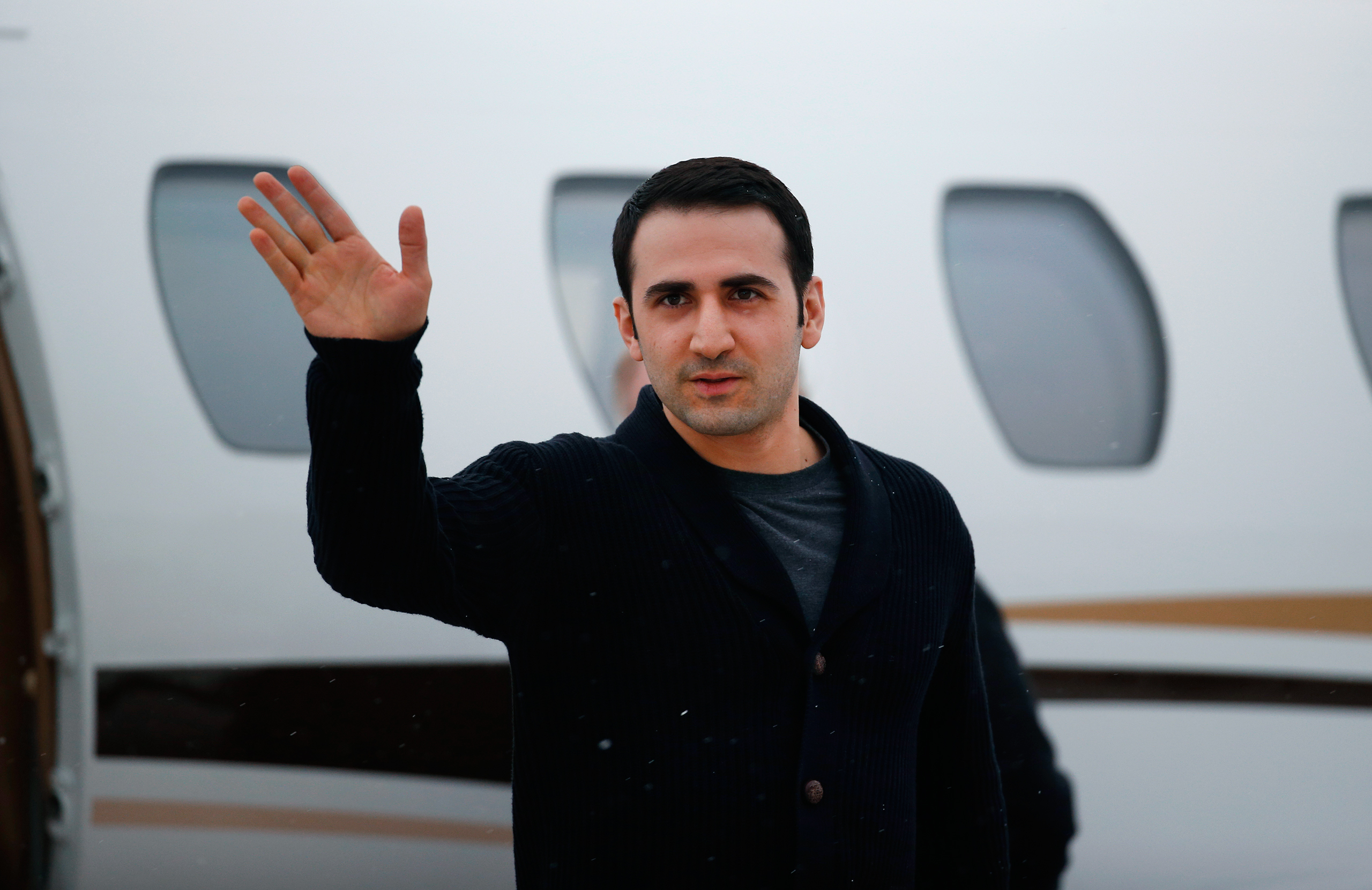 Amir Hekmati, the 32-year-old, former U.S. Marine, who had just been released from an Iranian prison, waves after arriving on a private flight at Bishop International Airport in Flint, Mich. on Jan. 21, 2016.