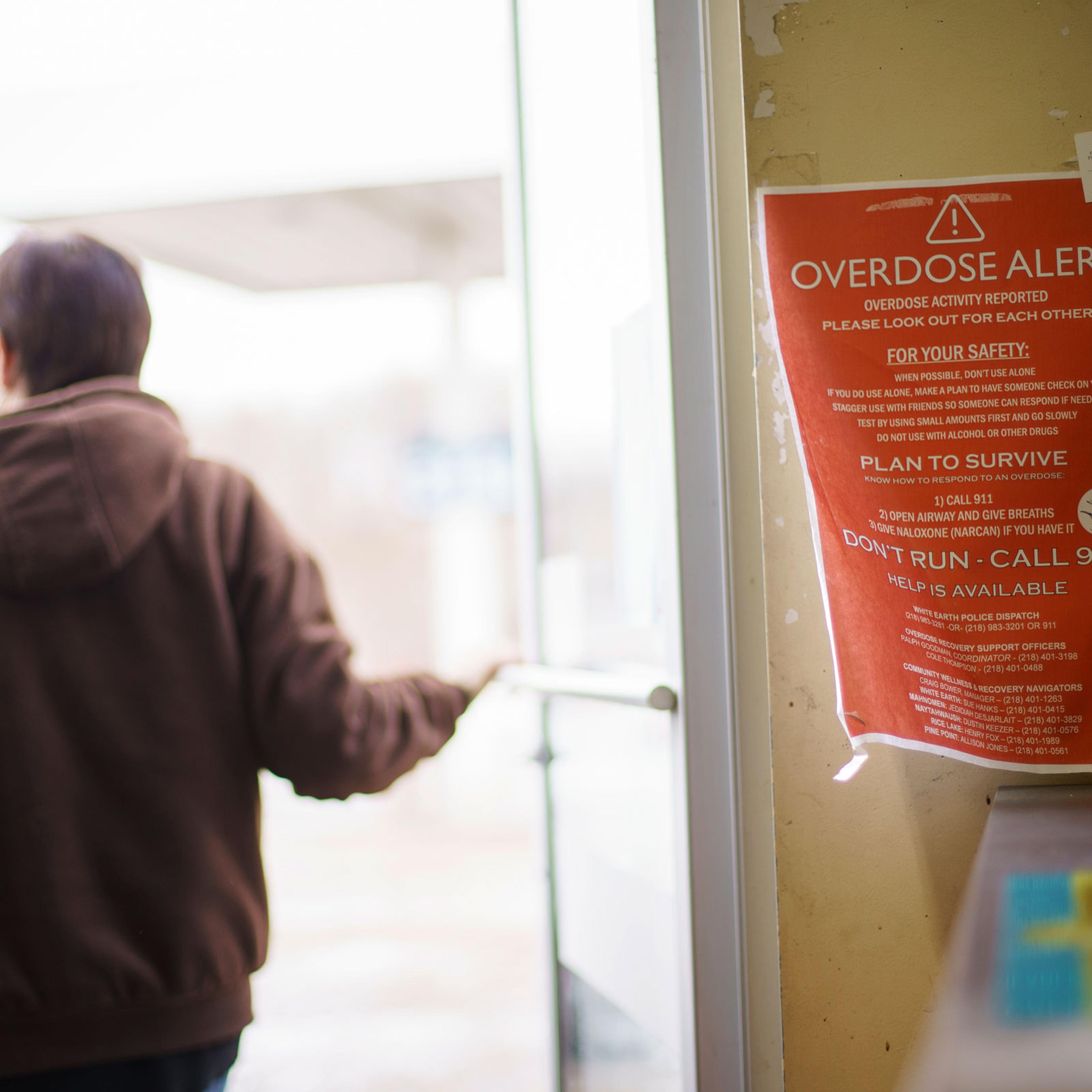 A sign calling attention to drug overdoses is posted to the door of a gas station