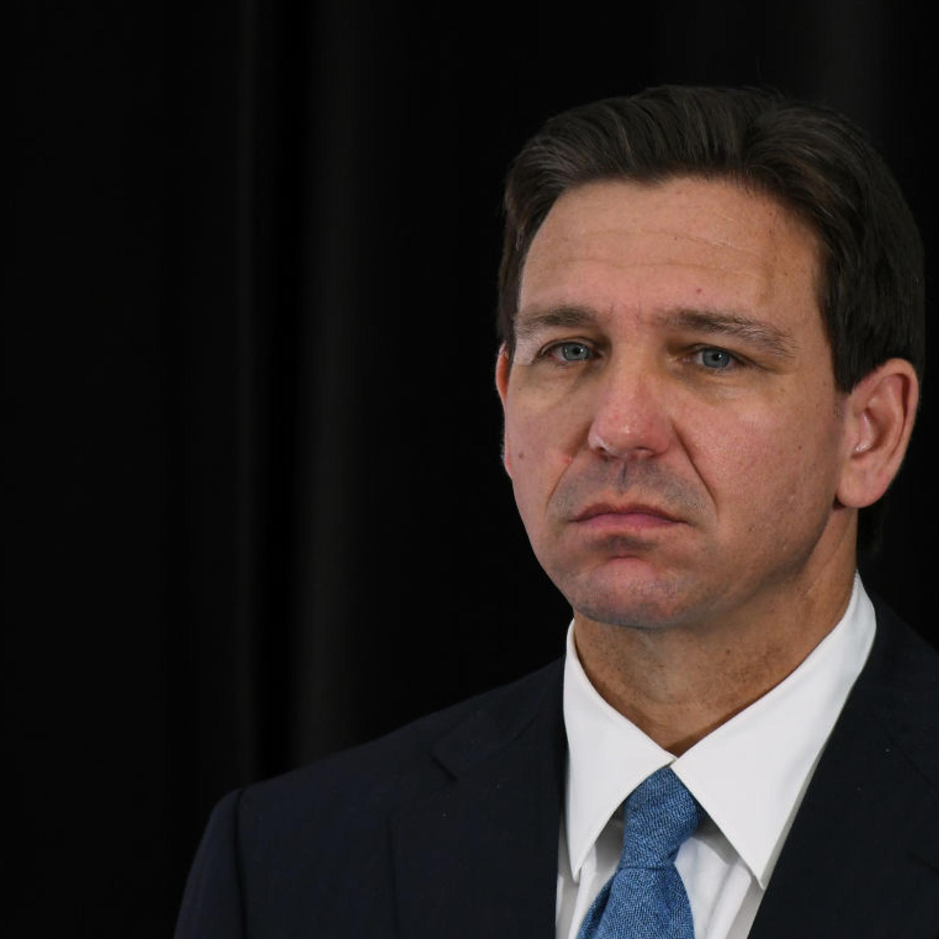 Florida Governor Ron DeSantis listens to a speaker at a