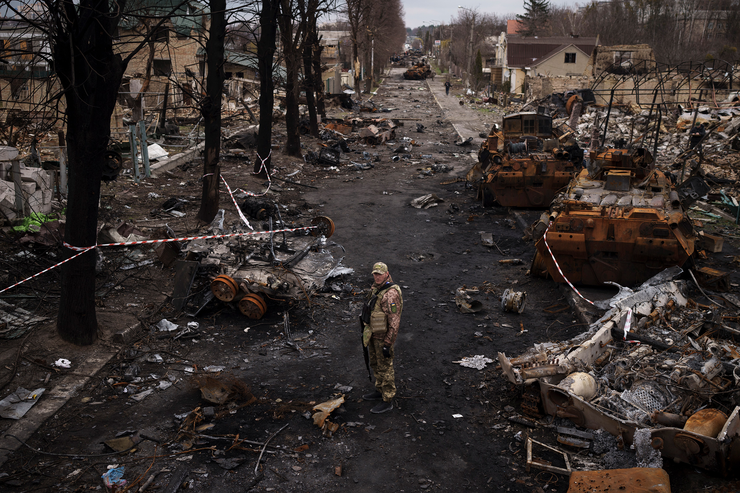 A Ukrainian serviceman stands amid destroyed Russian tanks in Bucha, on the outskirts of Kyiv, on April 6