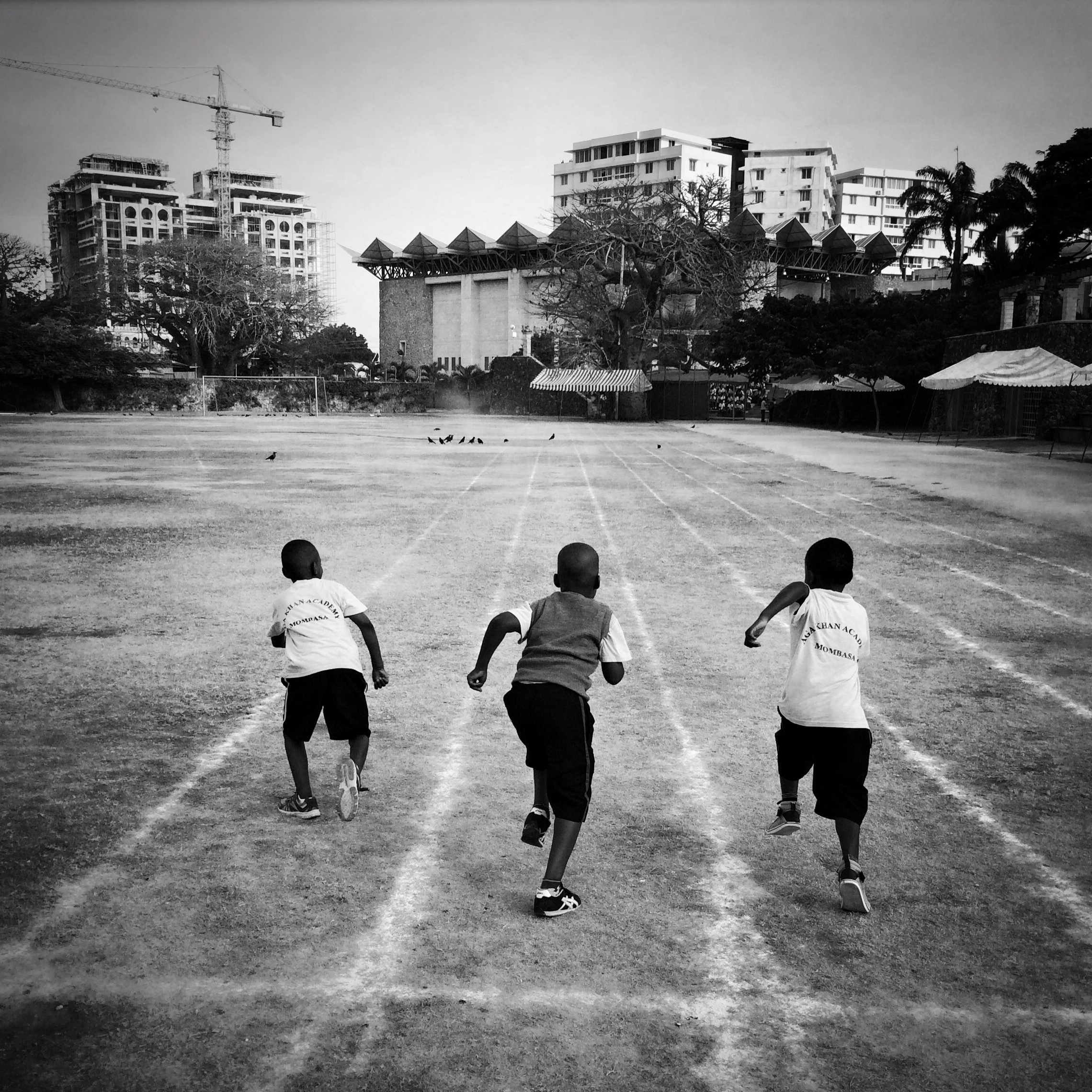 Three boys from the junior school at Aga Khan Academy in Mombasa, Kenya, race on the school's track in the morning prior to the start of the day. March 2015.