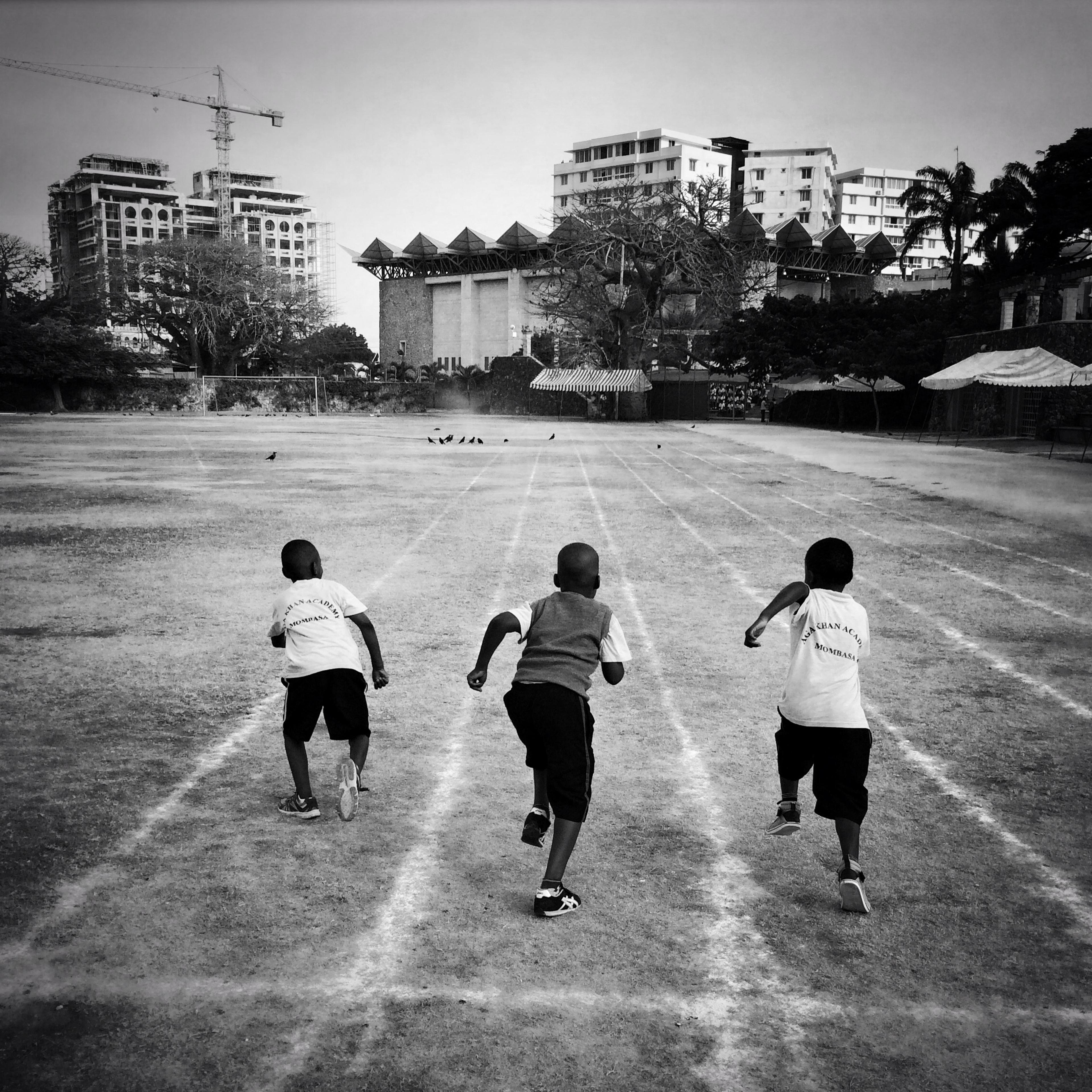 Three boys from the junior school at Aga Khan Academy in Mombasa, Kenya, race on the school's track in the morning prior to the start of the day. March 2015.