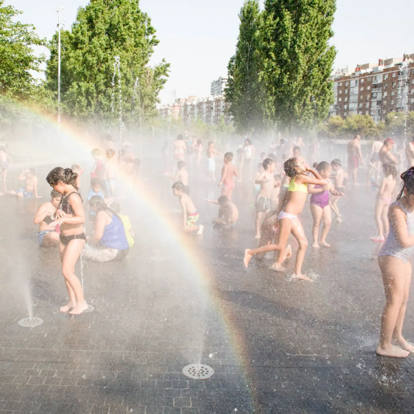 Children play and cool off in the water jets in Madrid on July 14.