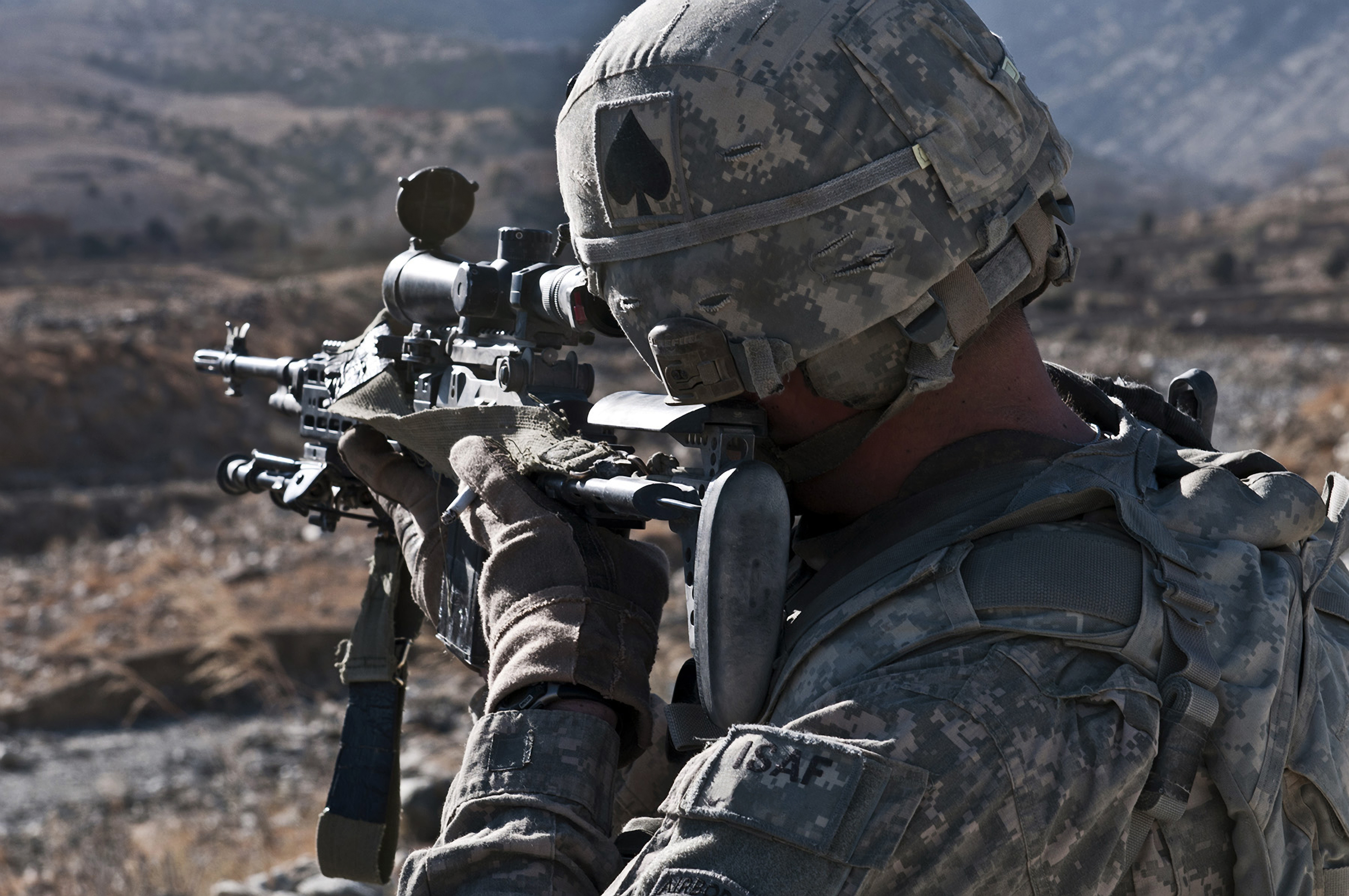 U.S. Army sniper scans a village in Afghanistan for Taliban activity.