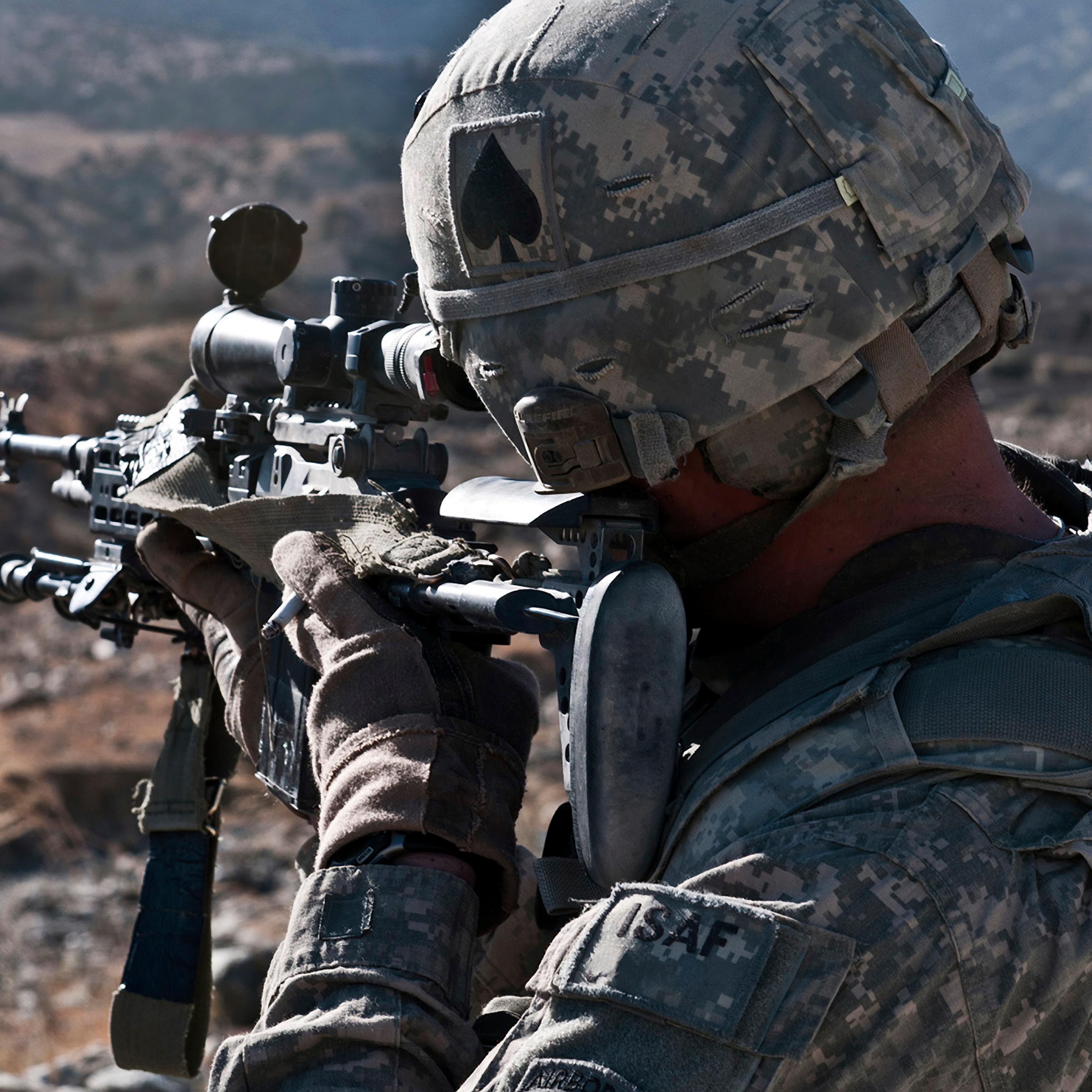 U.S. Army sniper scans a village in Afghanistan for Taliban activity.