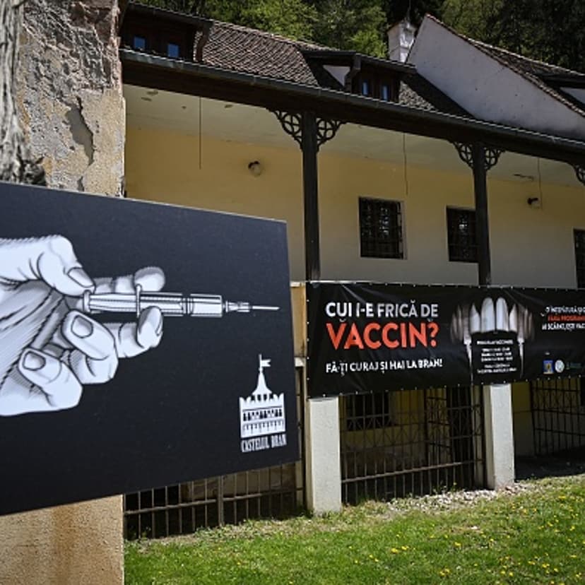 A banner reading "Who's afraid of the vaccine?" in Romanian and depicting syringes as vampire fangs advertises the vaccination marathon organized at "Bran Castle" in Bran village in the central Transylvania region of Romania on May 8, 2021.