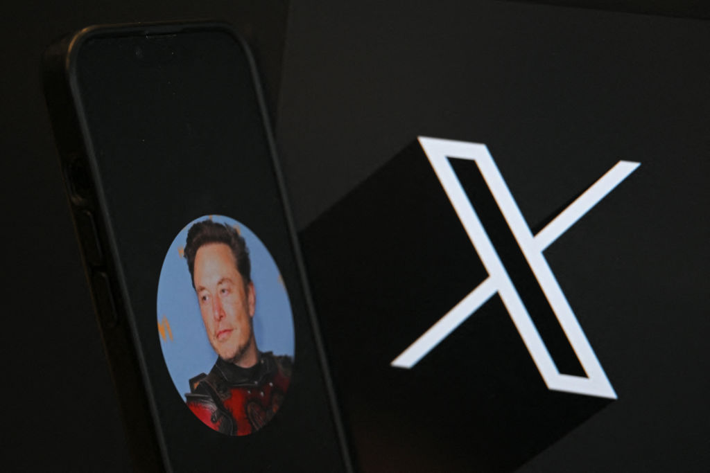 The logo of social network X and a photograph of its CEO Elon Musk, taken on Sept. 27, 2024.