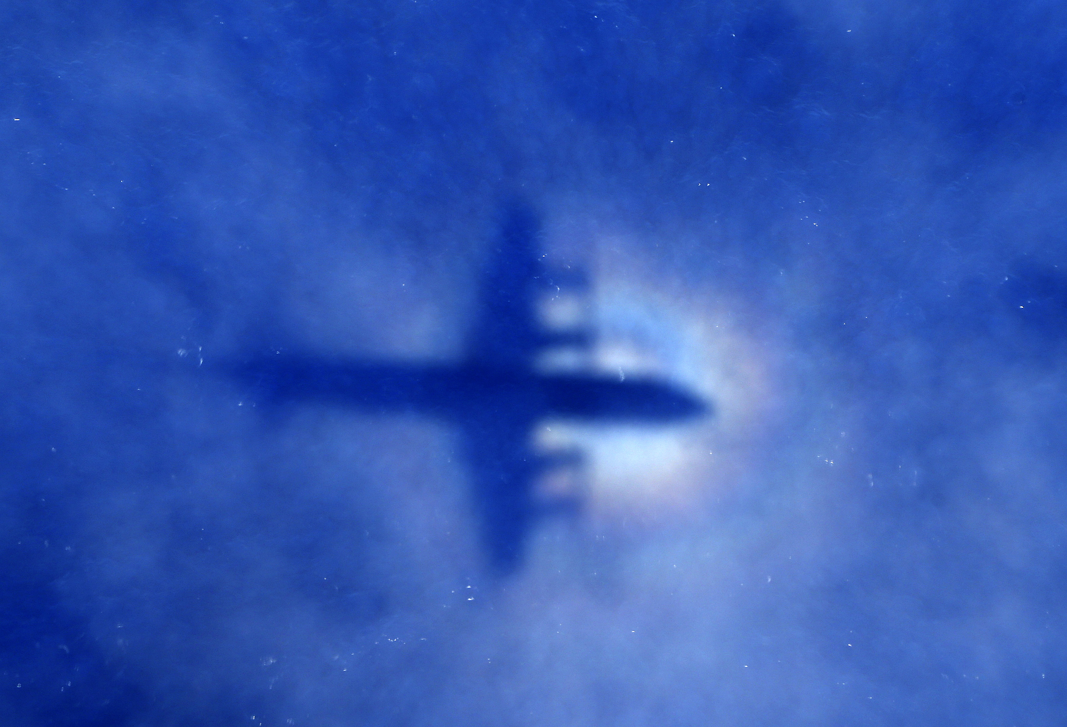 The shadow of a Royal New Zealand Air Force (RNZAF) P3 Orion maritime search aircraft can be seen on low-level clouds as it flies over the southern Indian Ocean looking for missing Malaysian Airlines flight MH370