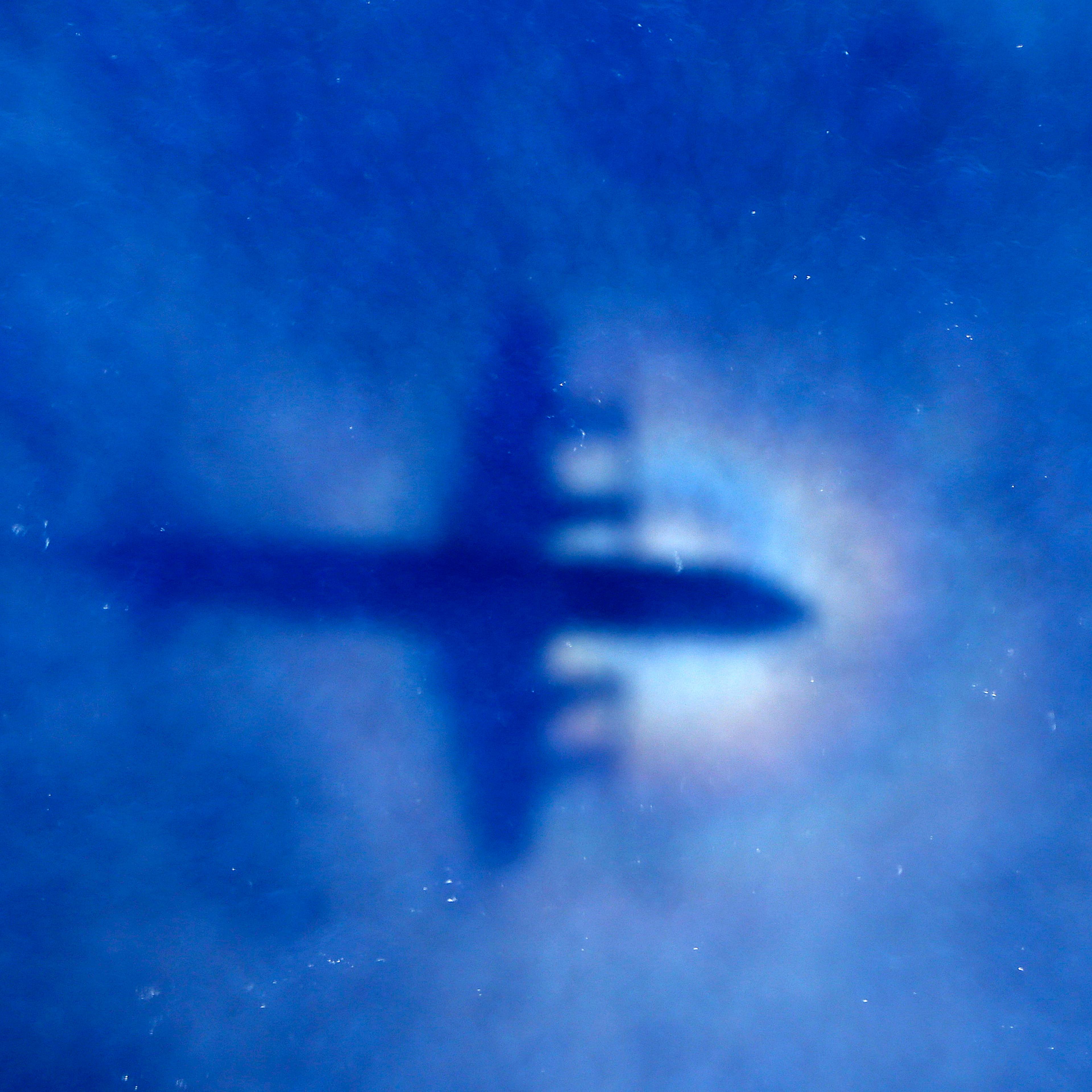 The shadow of a Royal New Zealand Air Force (RNZAF) P3 Orion maritime search aircraft can be seen on low-level clouds as it flies over the southern Indian Ocean looking for missing Malaysian Airlines flight MH370