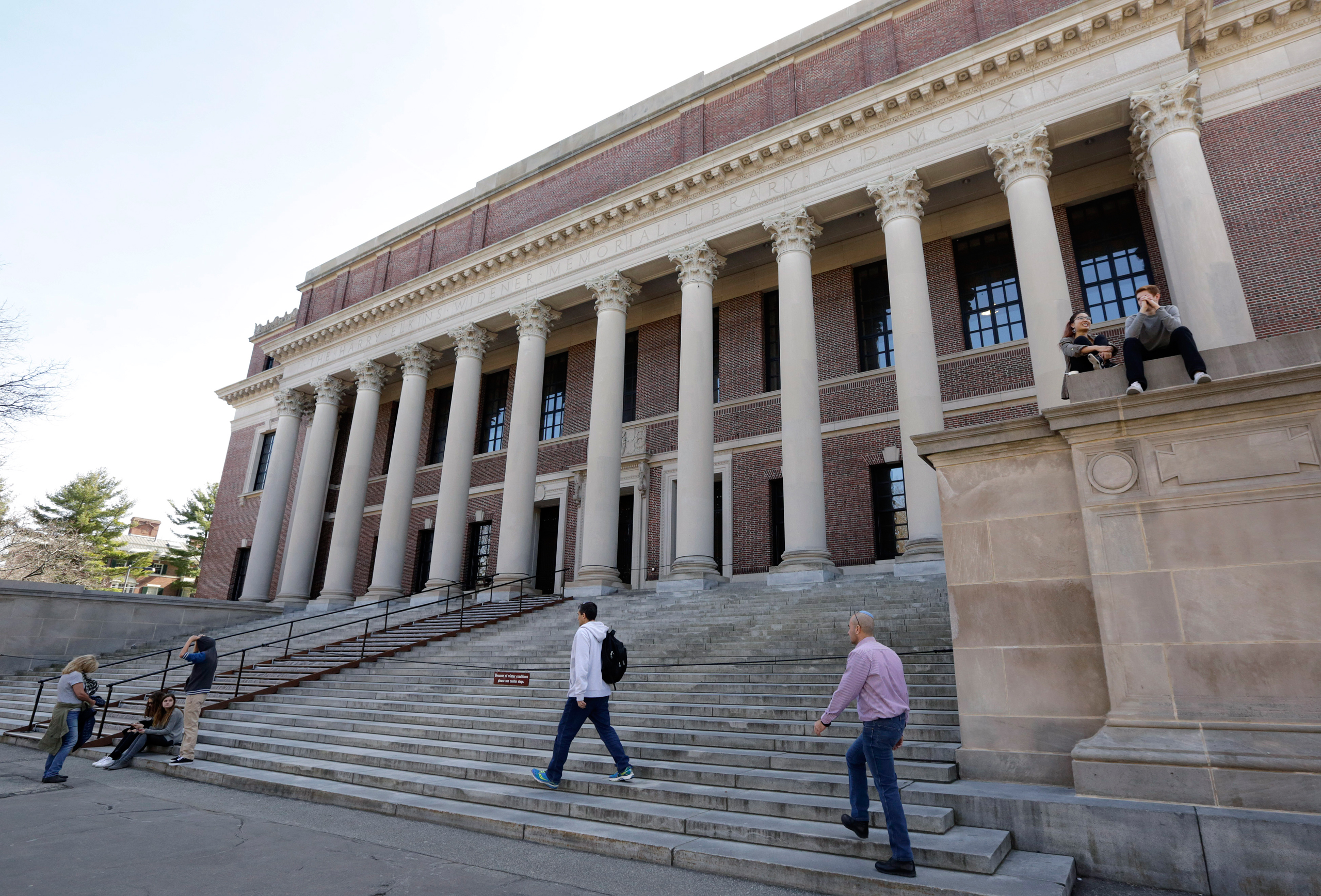 In this Sunday, March 13, 2016 photo, people gather in front of Widener Library on the campus of Harvard University, in Cambridge, Mass. (AP Photo/Steven Senne)