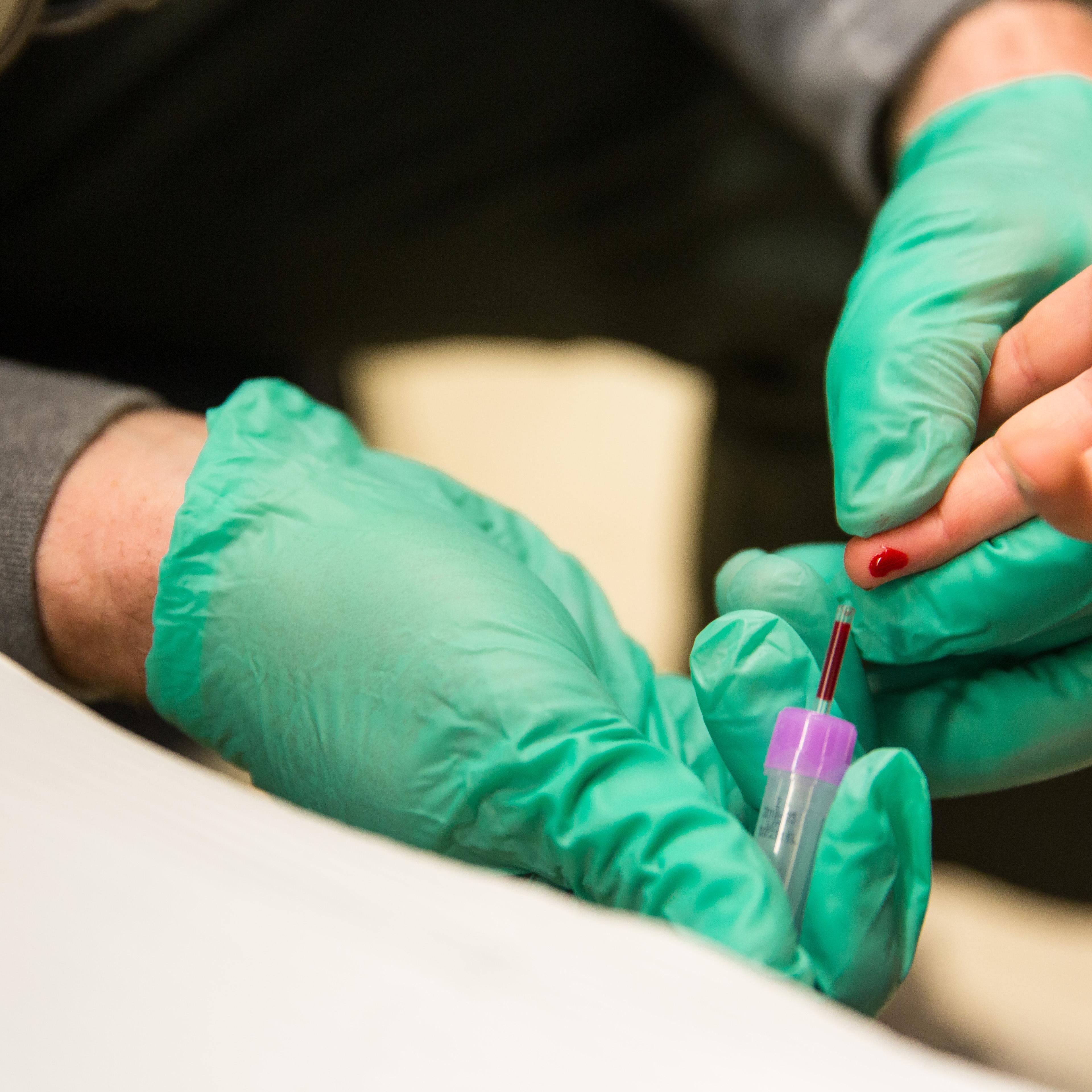 A first responder draws the blood of a five-year-old girl to screen her for lead at Eisenhower Elementary School in Flint, Mich., Jan. 26, 2016.