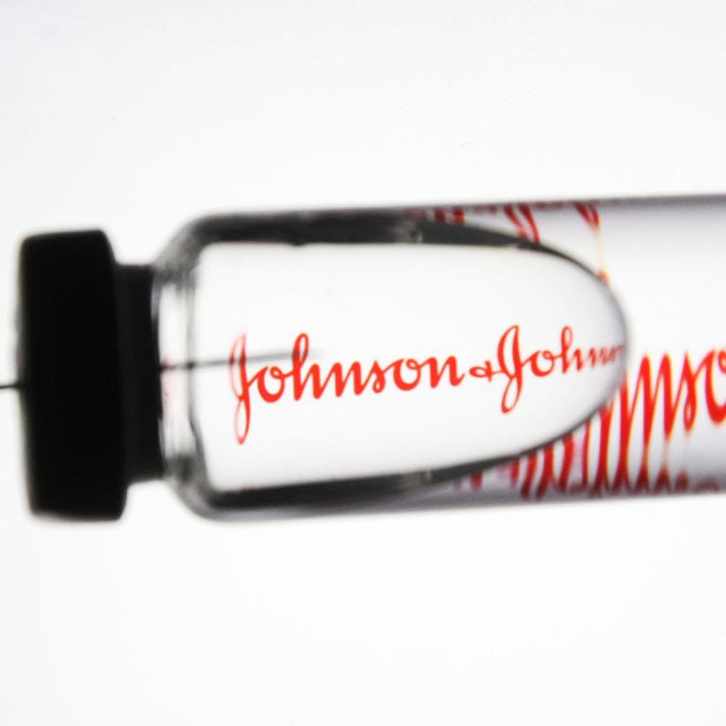 In this photo illustration a medical syringe and a vial with
