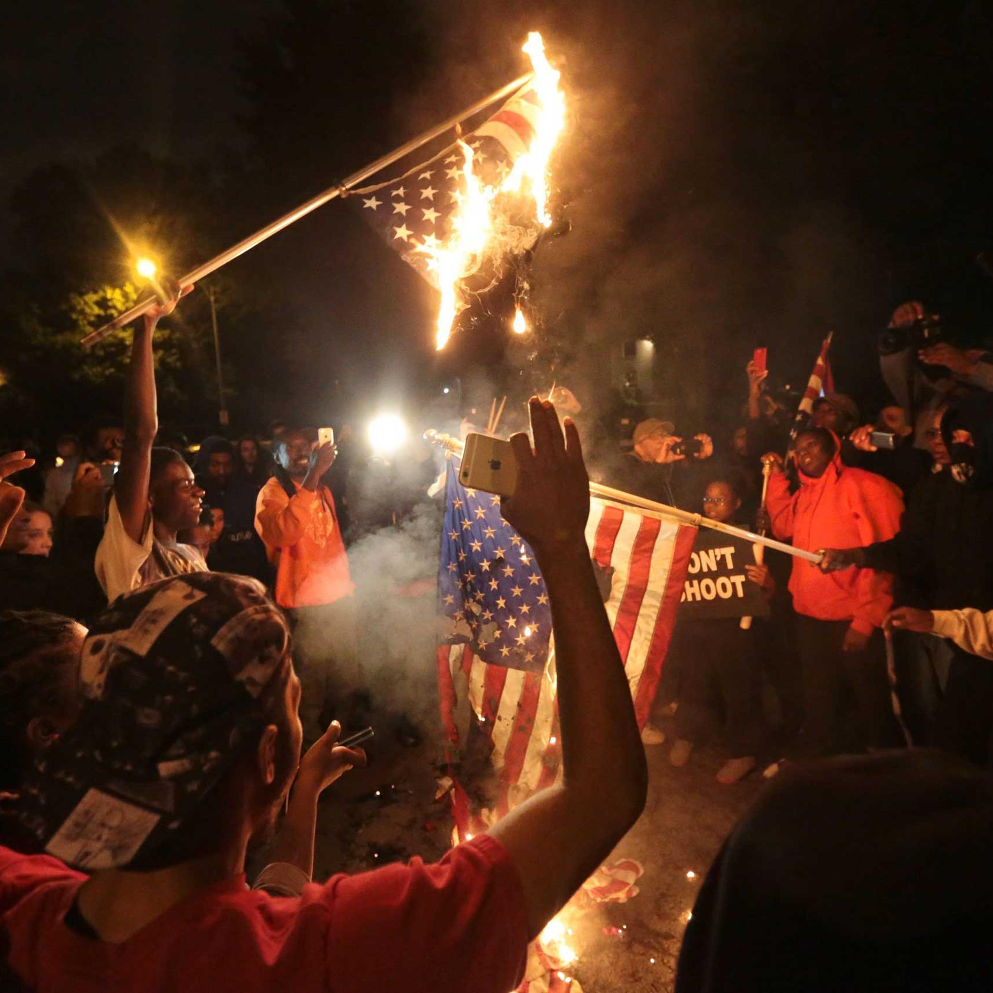 Several American flags are burned during a night of protest after a candlelight vigil for Vonderrit Myers, Jr. in St. Louis on Oct. 8, 2014.