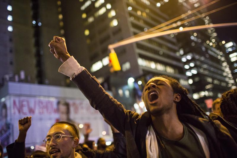 People take part in a protest against the grand jury decision on the death of Eric Garner in midtown Manhattan in New York