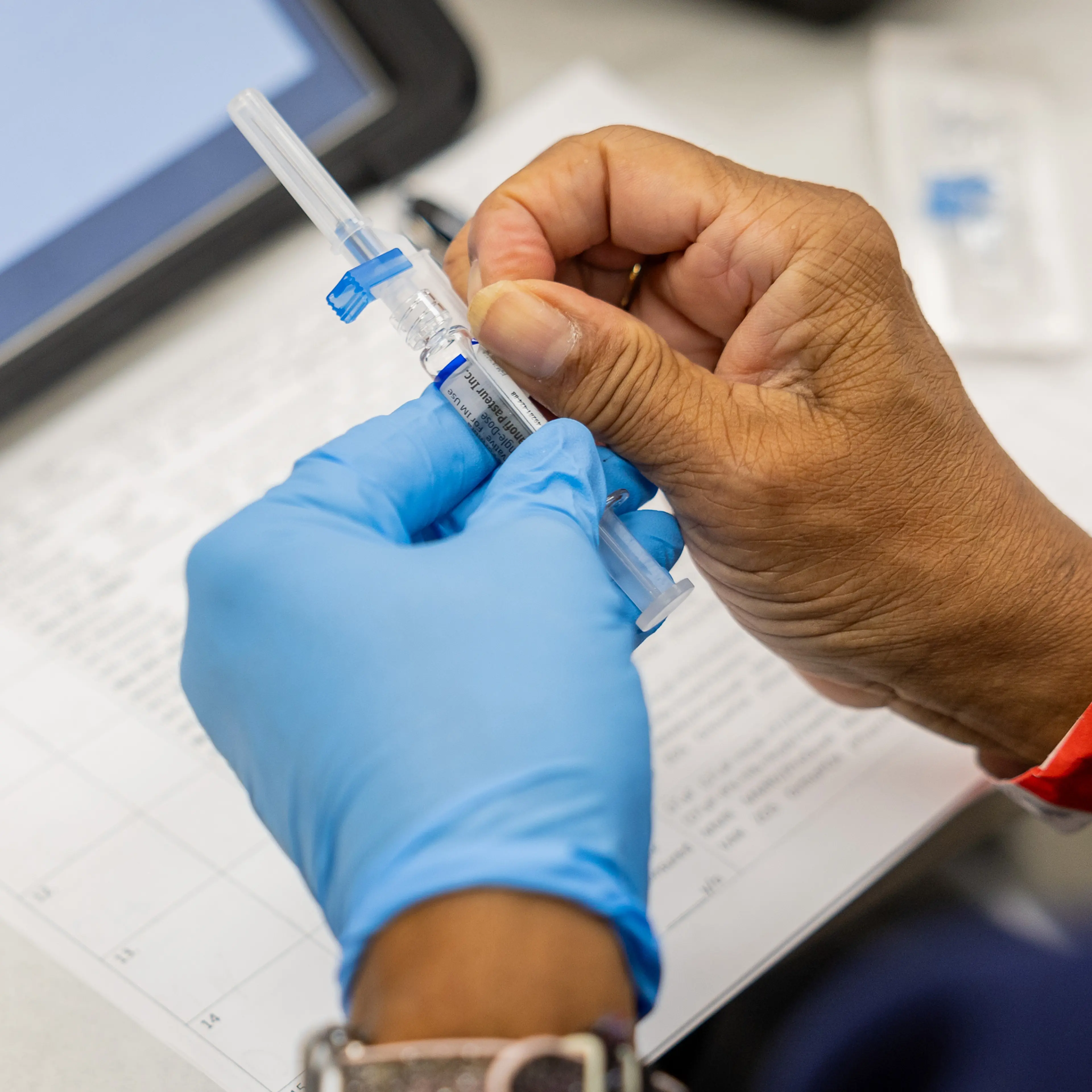 A nurse prepares to give a flu shot.