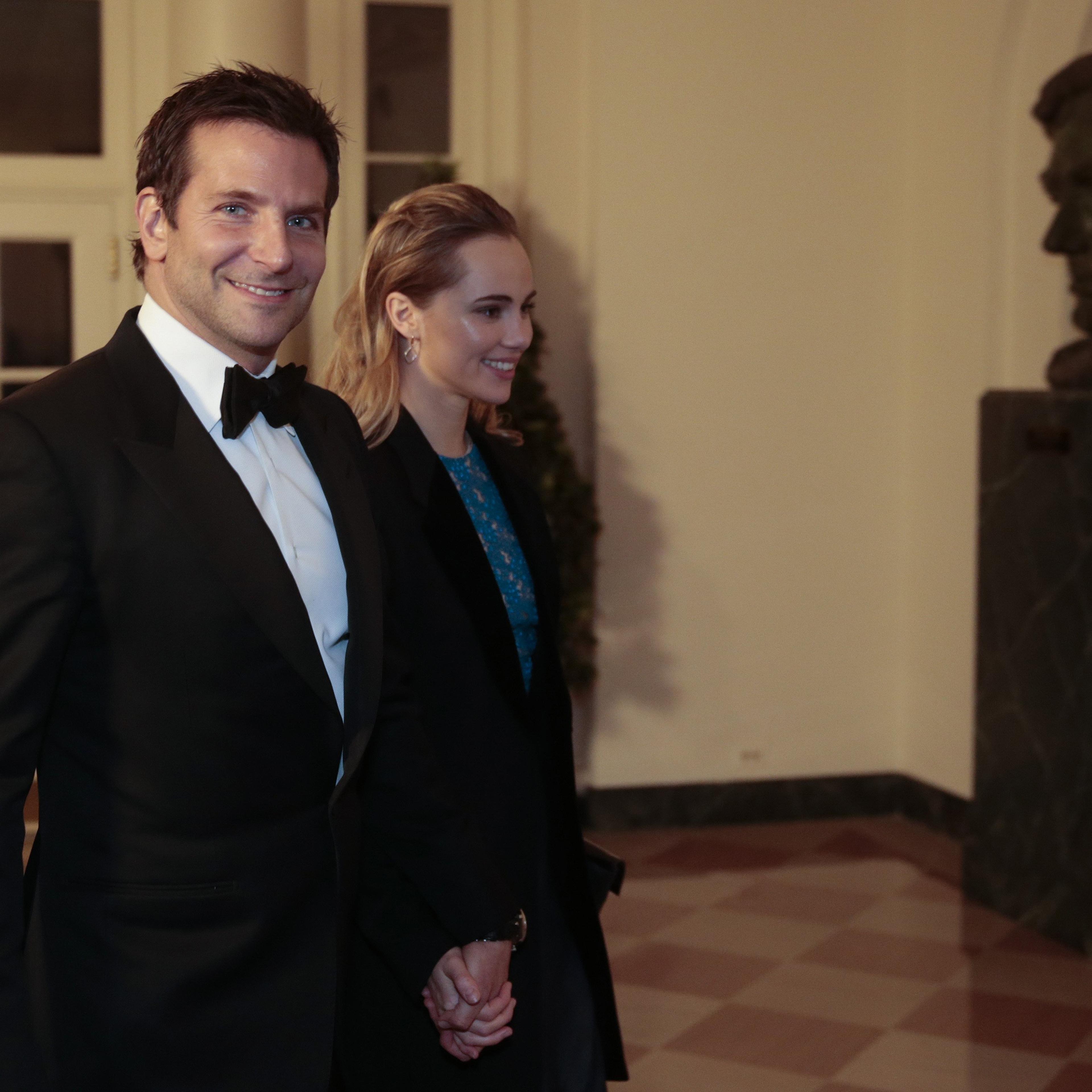 Actor Bradley Cooper, left, and Suki Waterhouse arrive to a state dinner hosted by U.S. President Barack Obama and U.S. first lady Michelle Obama in honor of French President Francois Hollande at the White House on February 11, 2014 in Washington.