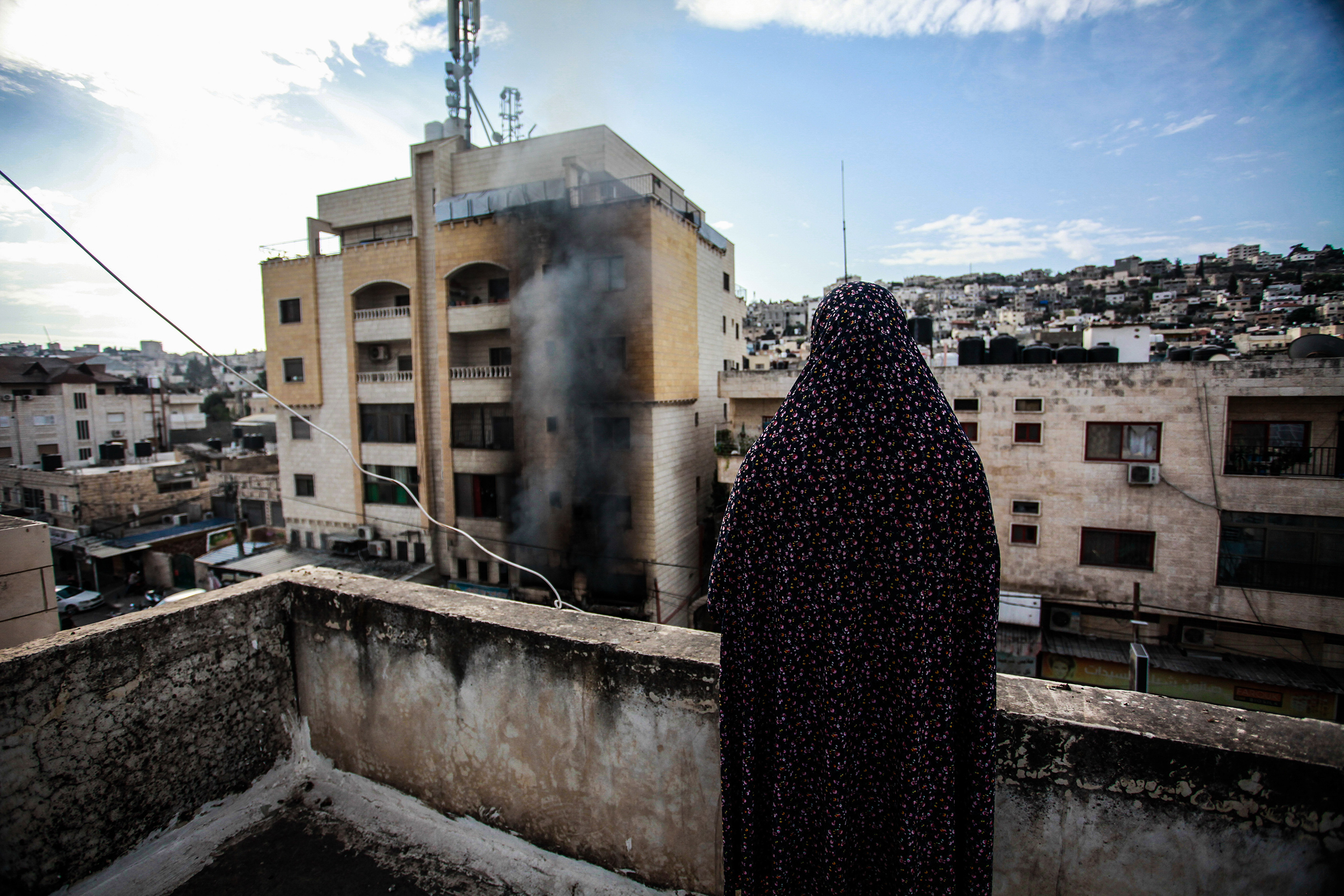 A Palestinian woman looks at a destroyed building following an Israeli military raid on the Jenin Palestinian refugee camp on Oct. 30.