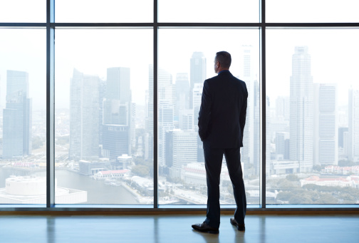 businessman-standing-looking-out-window