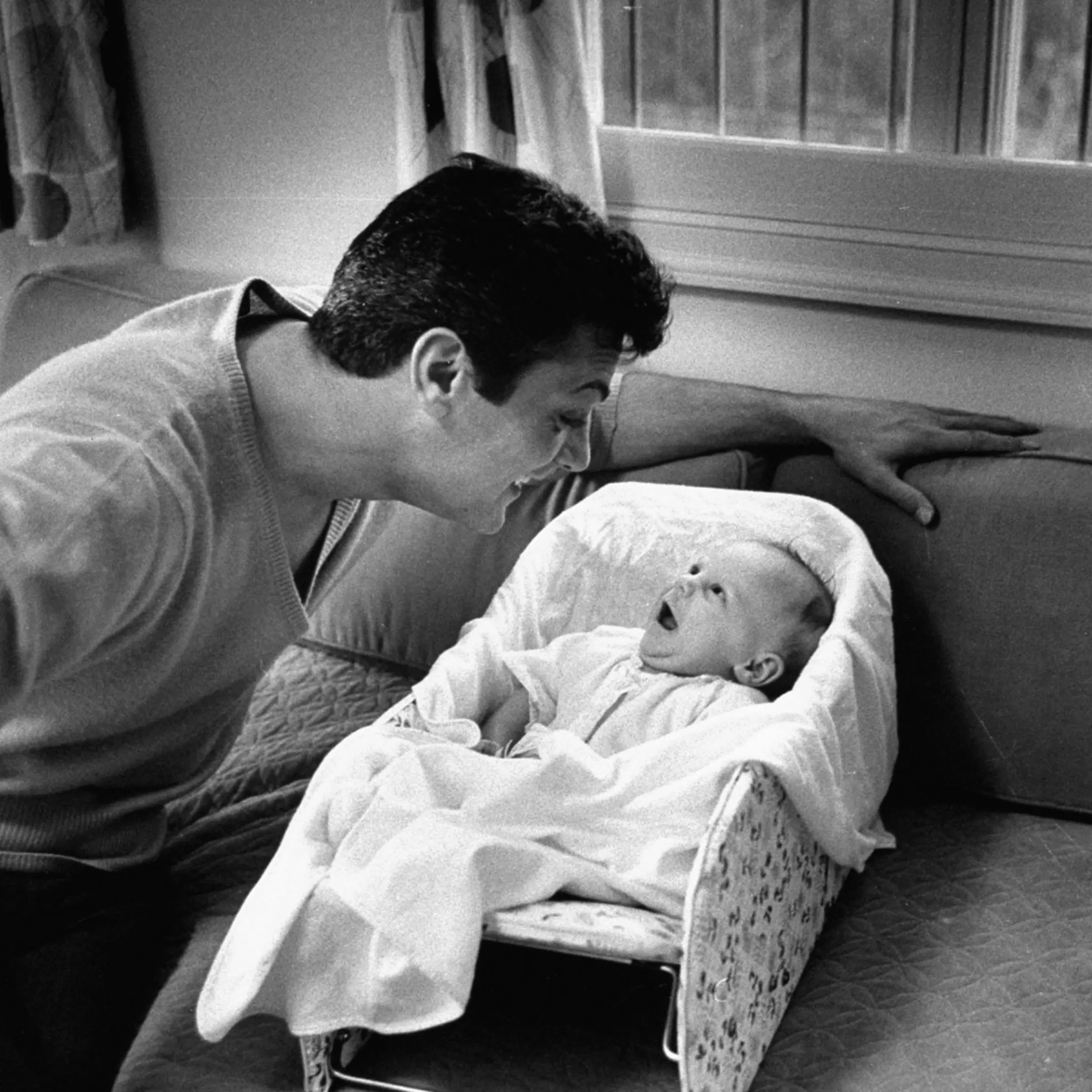 Tony Curtis smiles at his daughter, Jamie Lee, in 1959.
