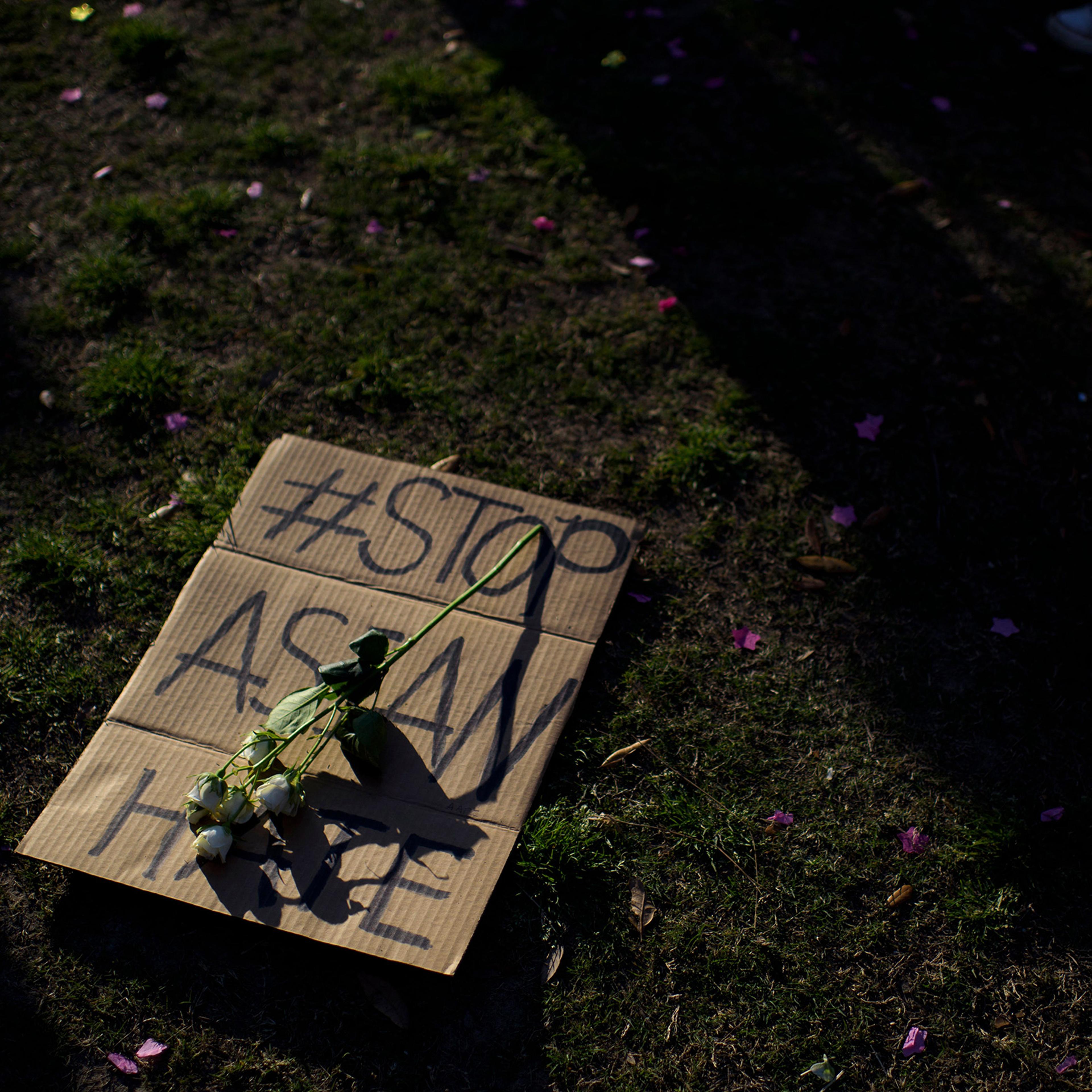 A sign is laid on the grass during a Stop Asian Hate rally in Houston on March 20, 2021.