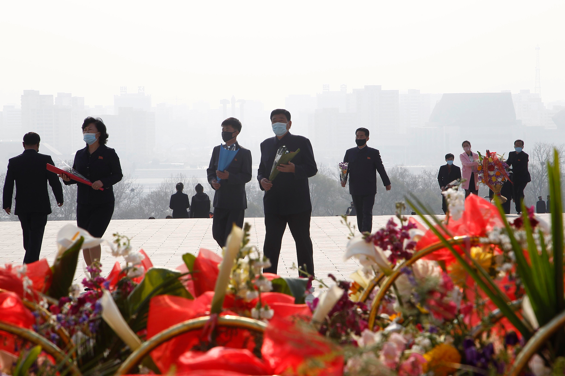 People visit Mansu Hill to lay flowers beneath bronze statues of late leaders Kim Il Sung and Kim Jong Il on April 15, the 108th birth anniversary of Kim Il Sung, in Pyongyang