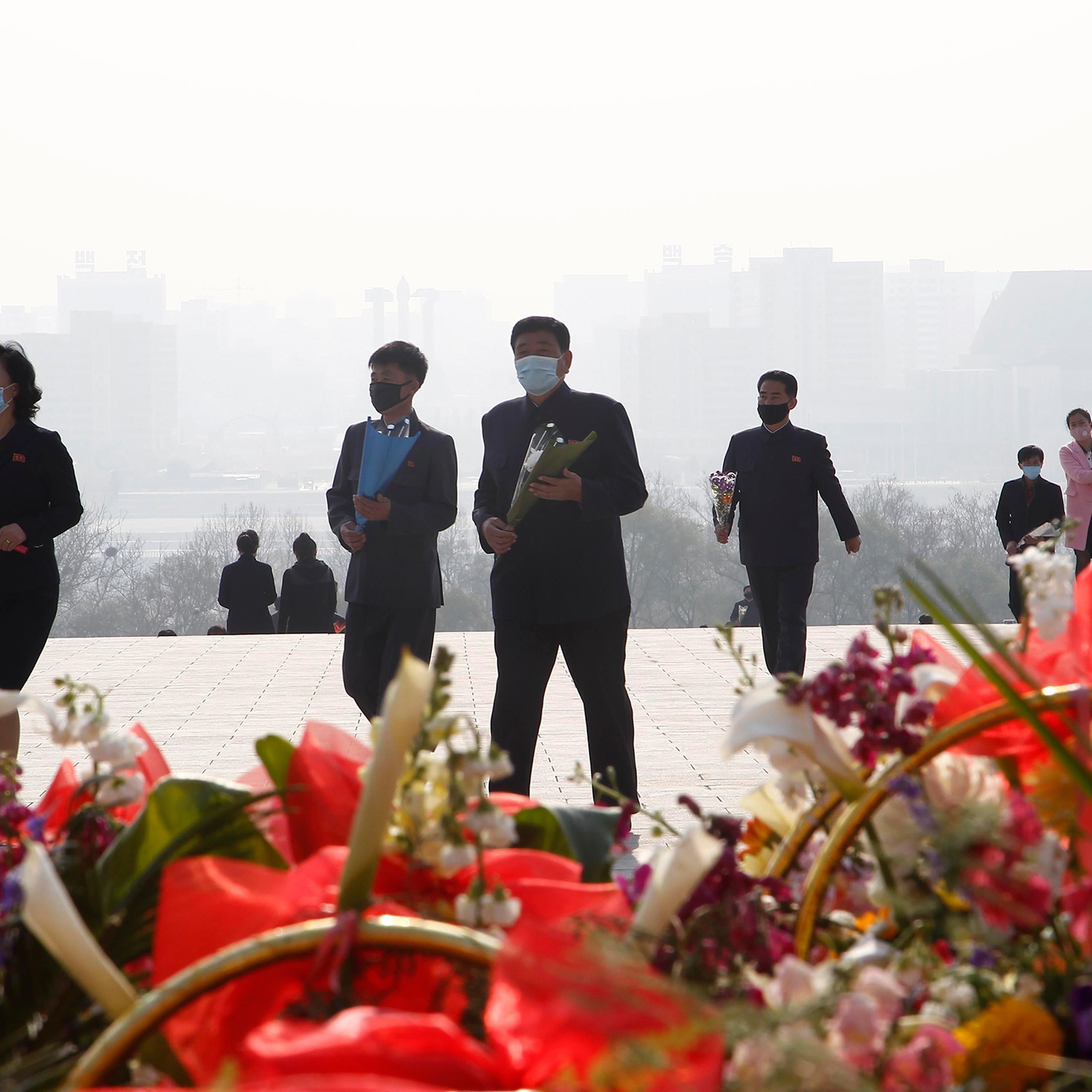 People visit Mansu Hill to lay flowers beneath bronze statues of late leaders Kim Il Sung and Kim Jong Il on April 15, the 108th birth anniversary of Kim Il Sung, in Pyongyang