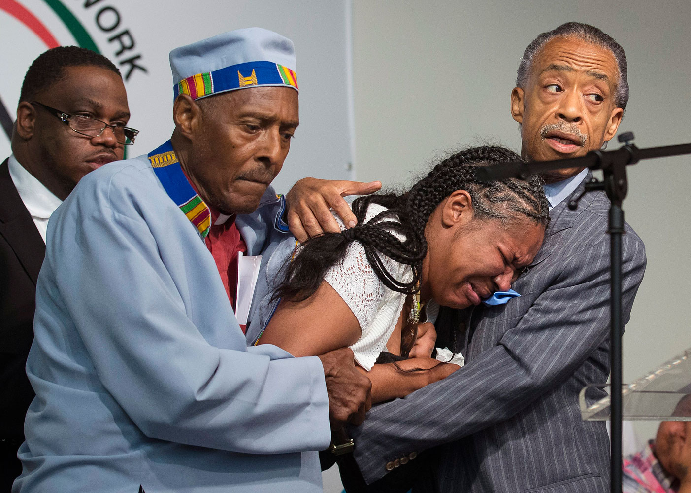 Rev. Herbert Daughtry and Rev. Al Sharpton hold Esaw Garner, wife of Eric Garner, during a rally at the National Action Network headquarters for Eric Garner, July 19, 2014, in New York City.